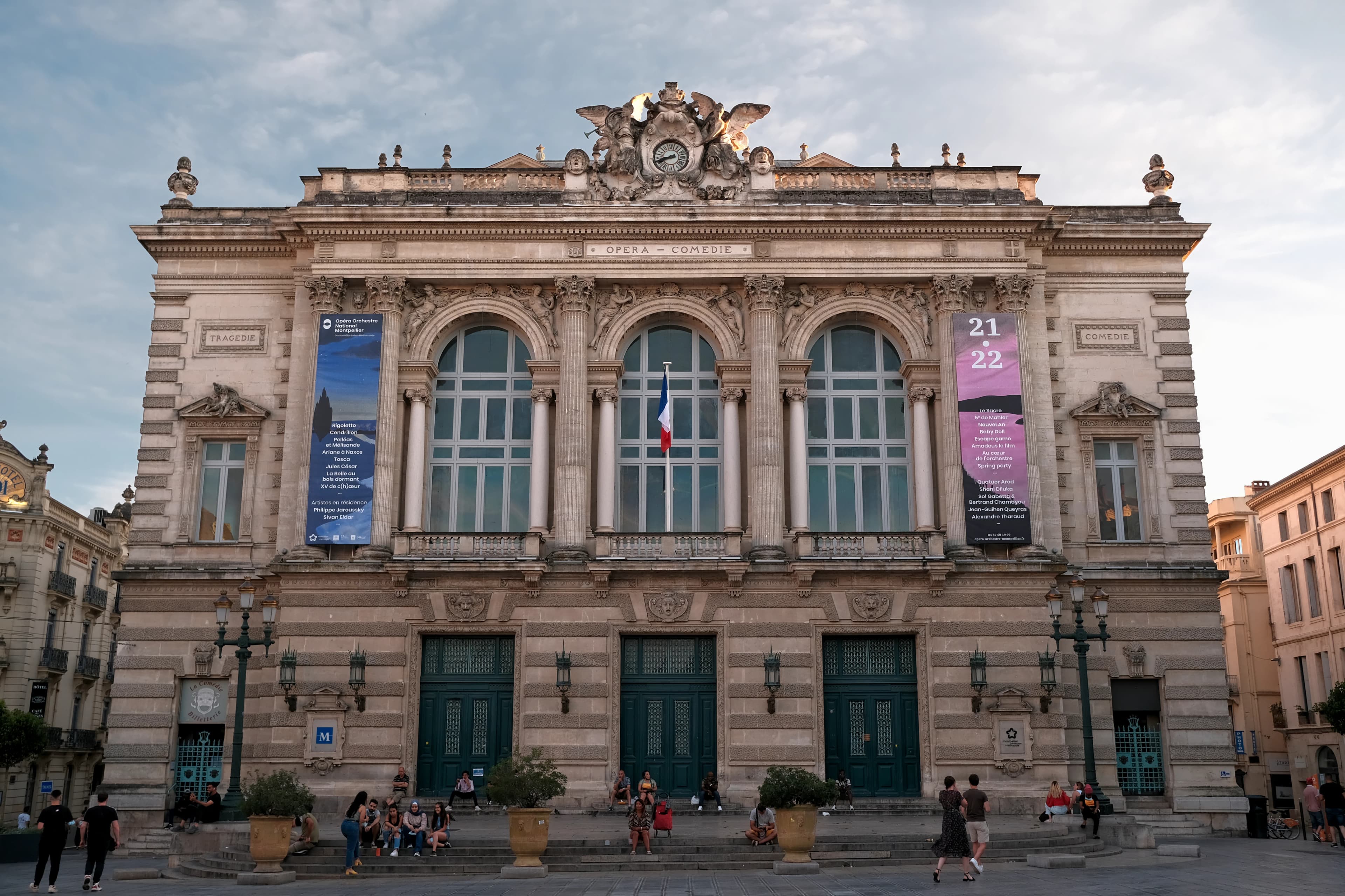 a large building with a lot of windows and people walking around