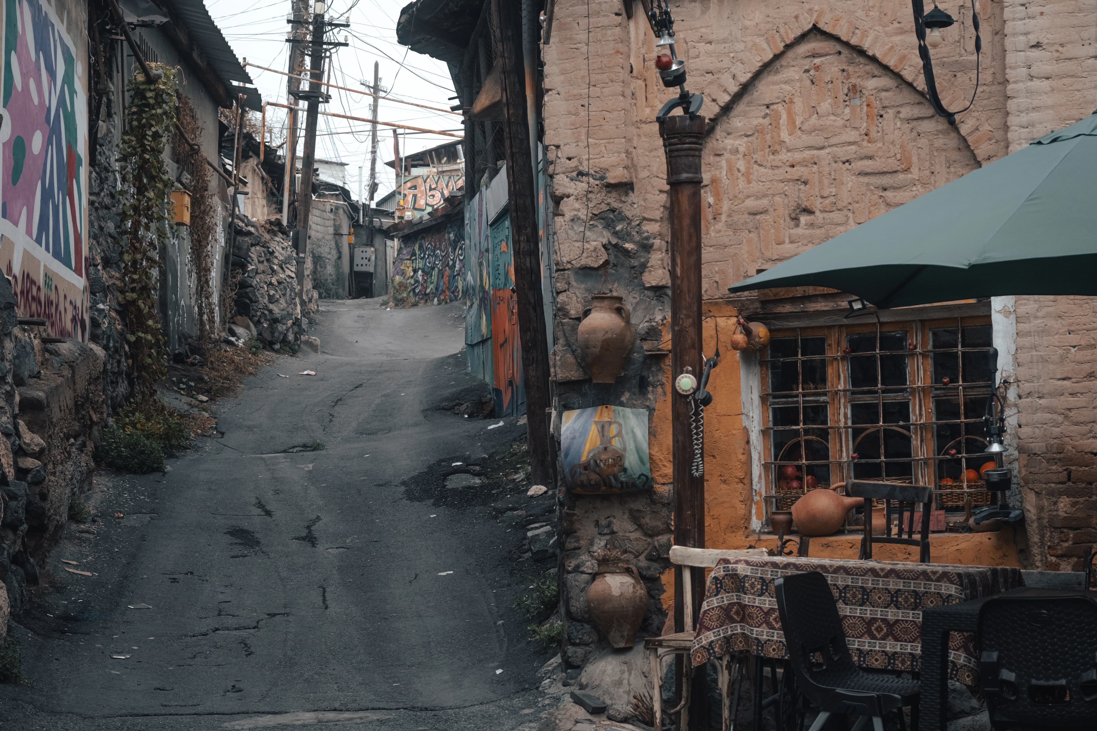 Narrow street with old buildings and a cafe