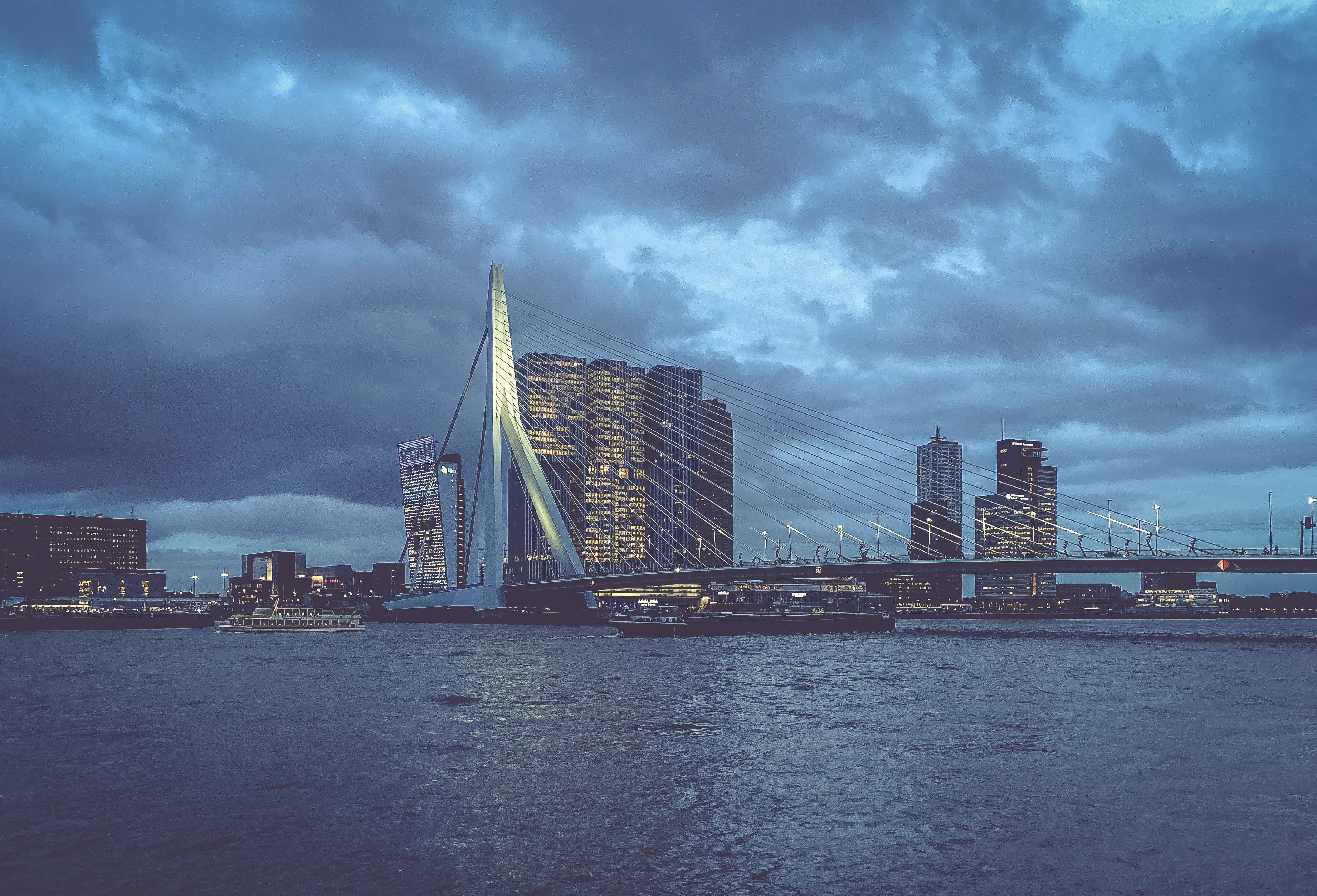 city skyline across body of water under cloudy sky during daytime