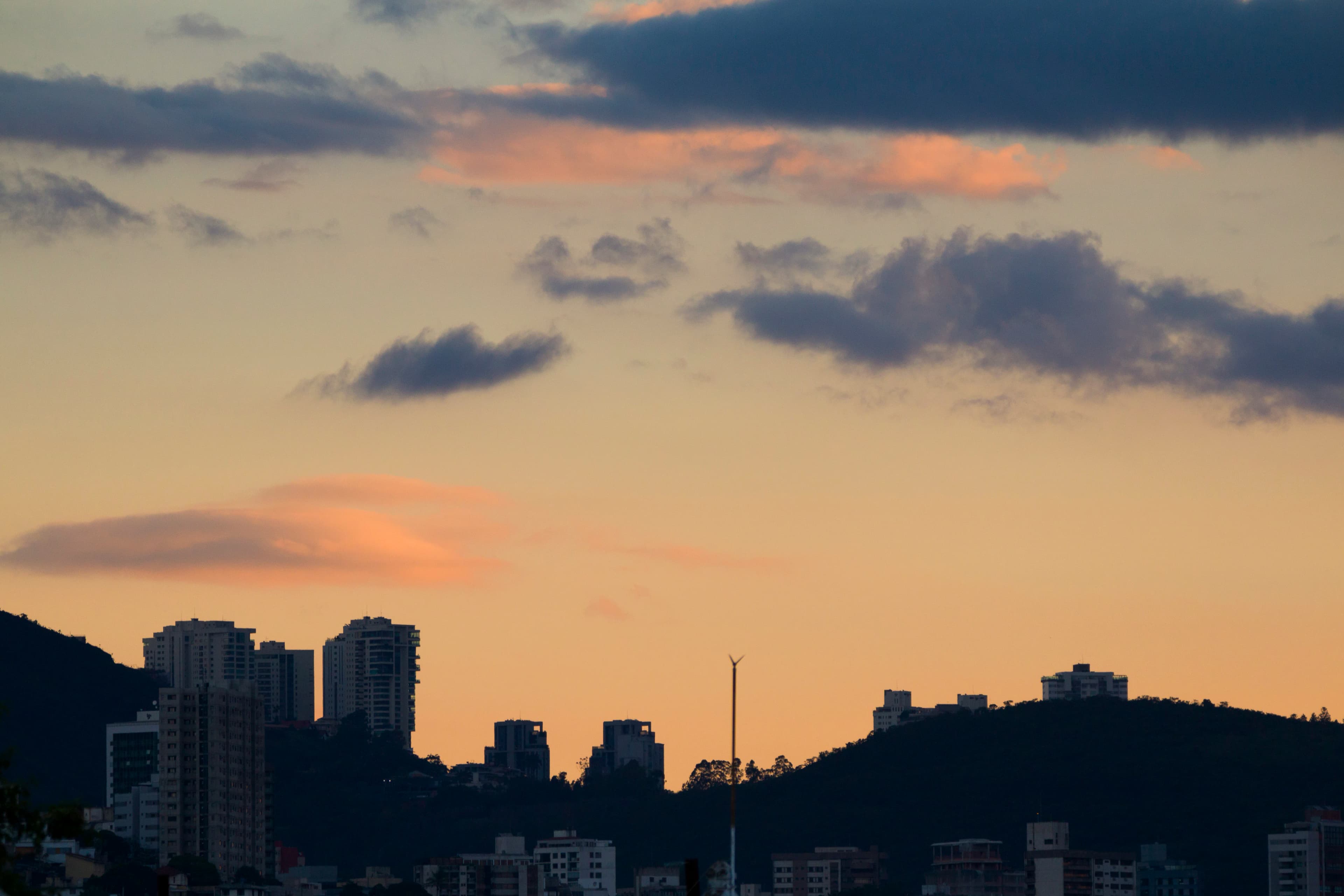 City skyline silhouetted against a colorful sunset sky.