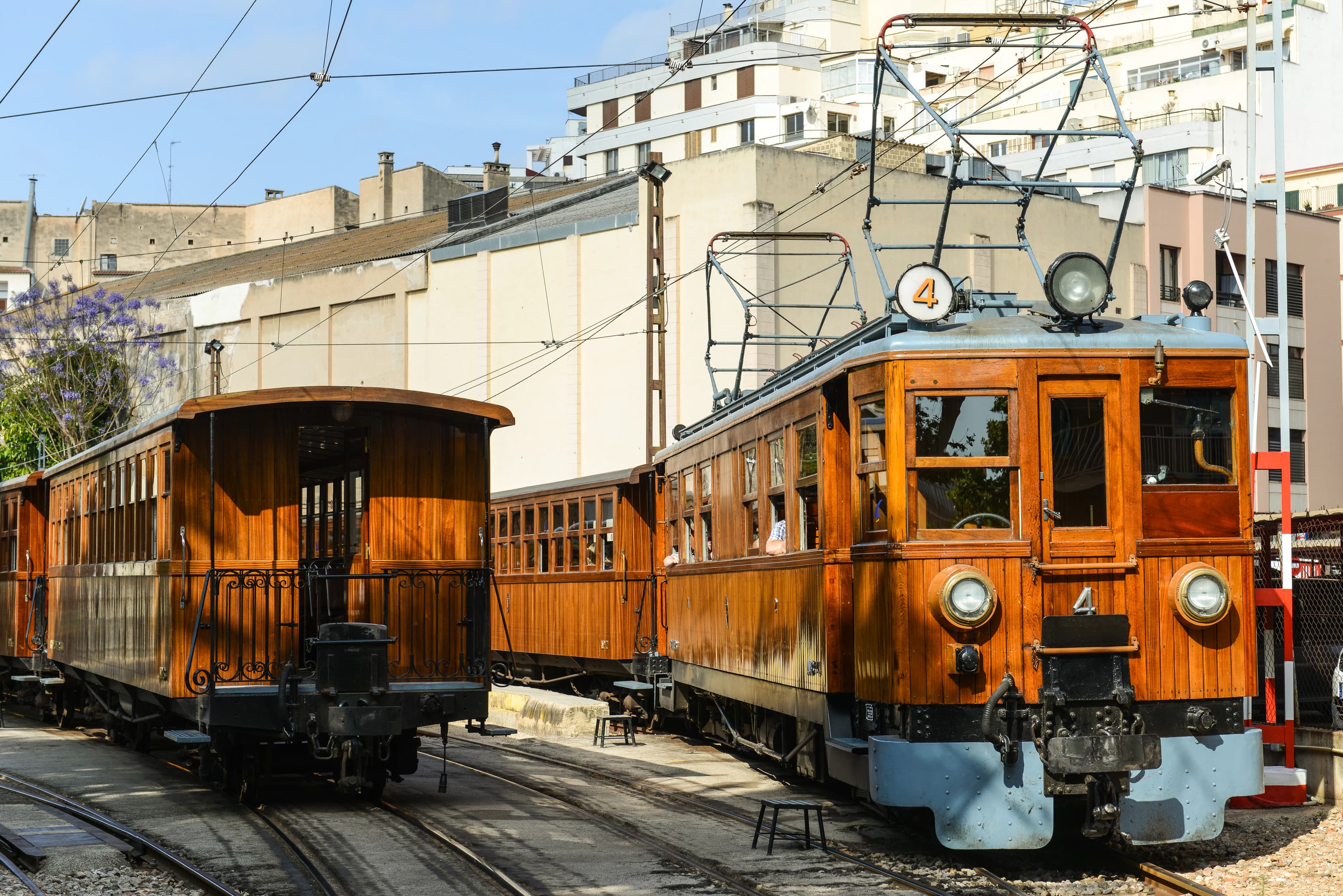 Two vintage wooden trams on railway tracks.