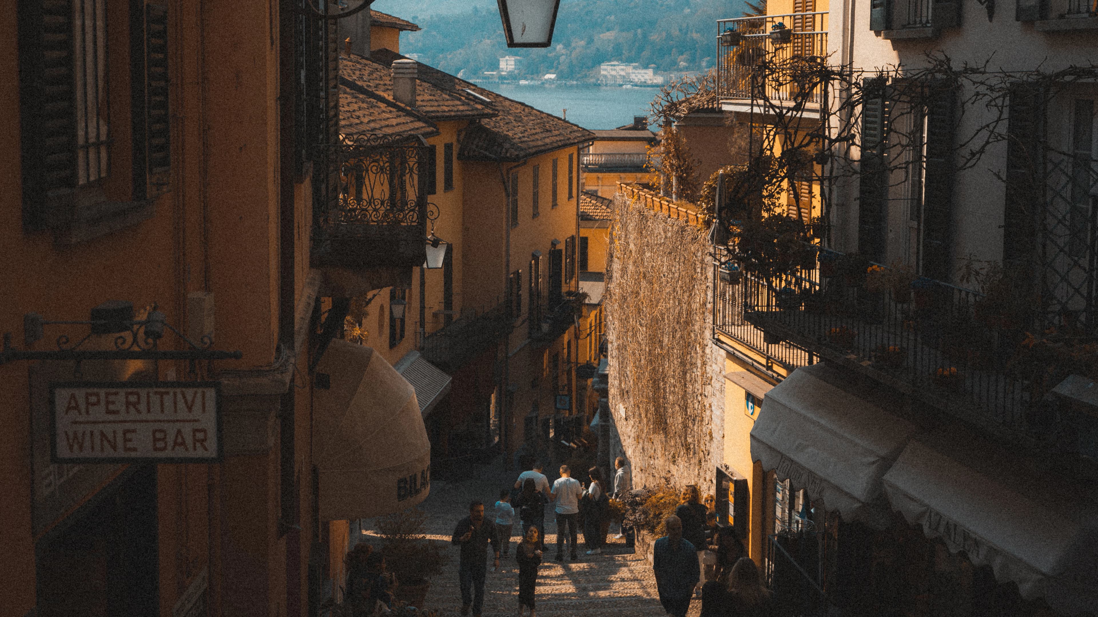 a group of people walking down a street next to tall buildings