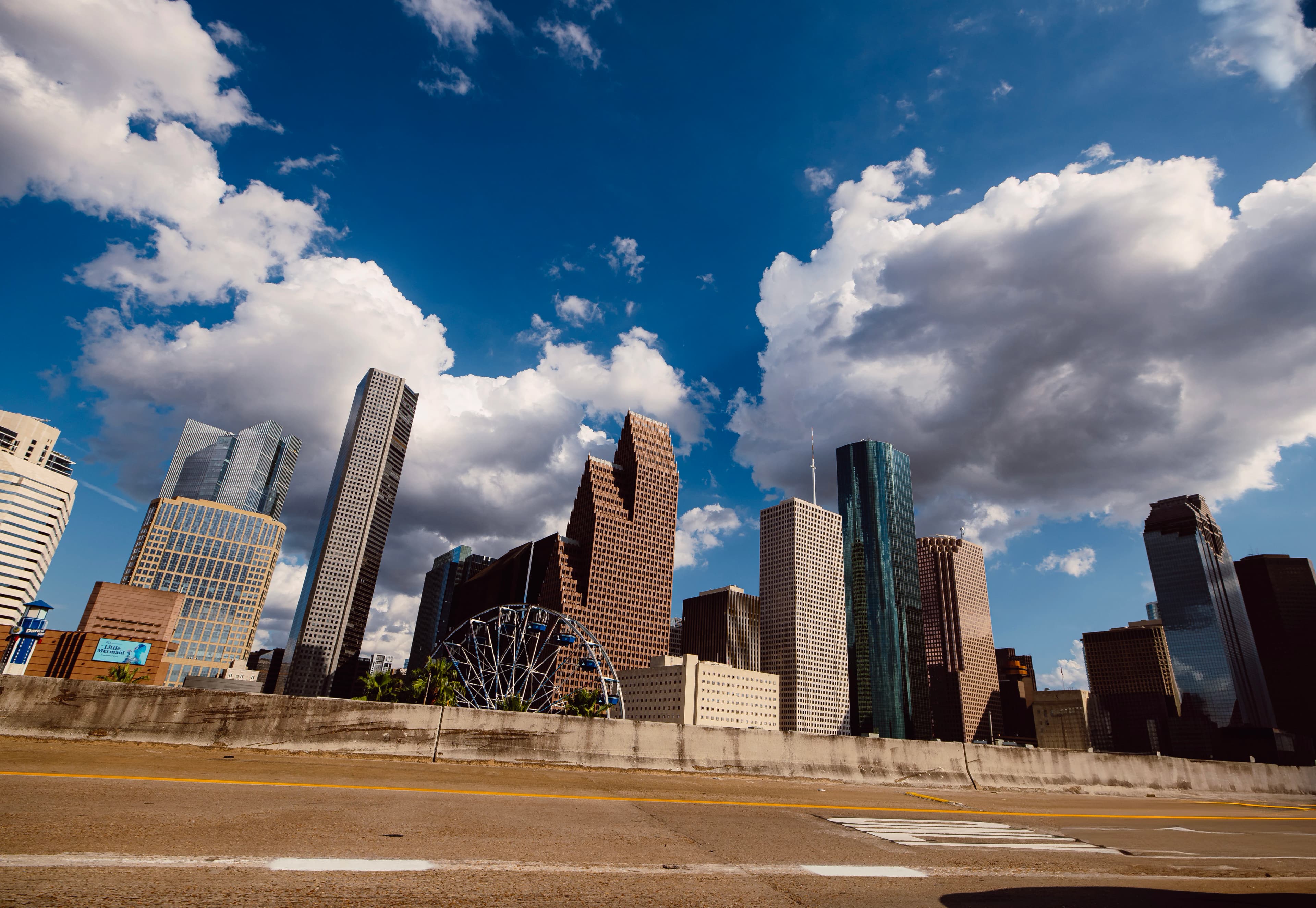 Modern skyscrapers under a cloudy blue sky.
