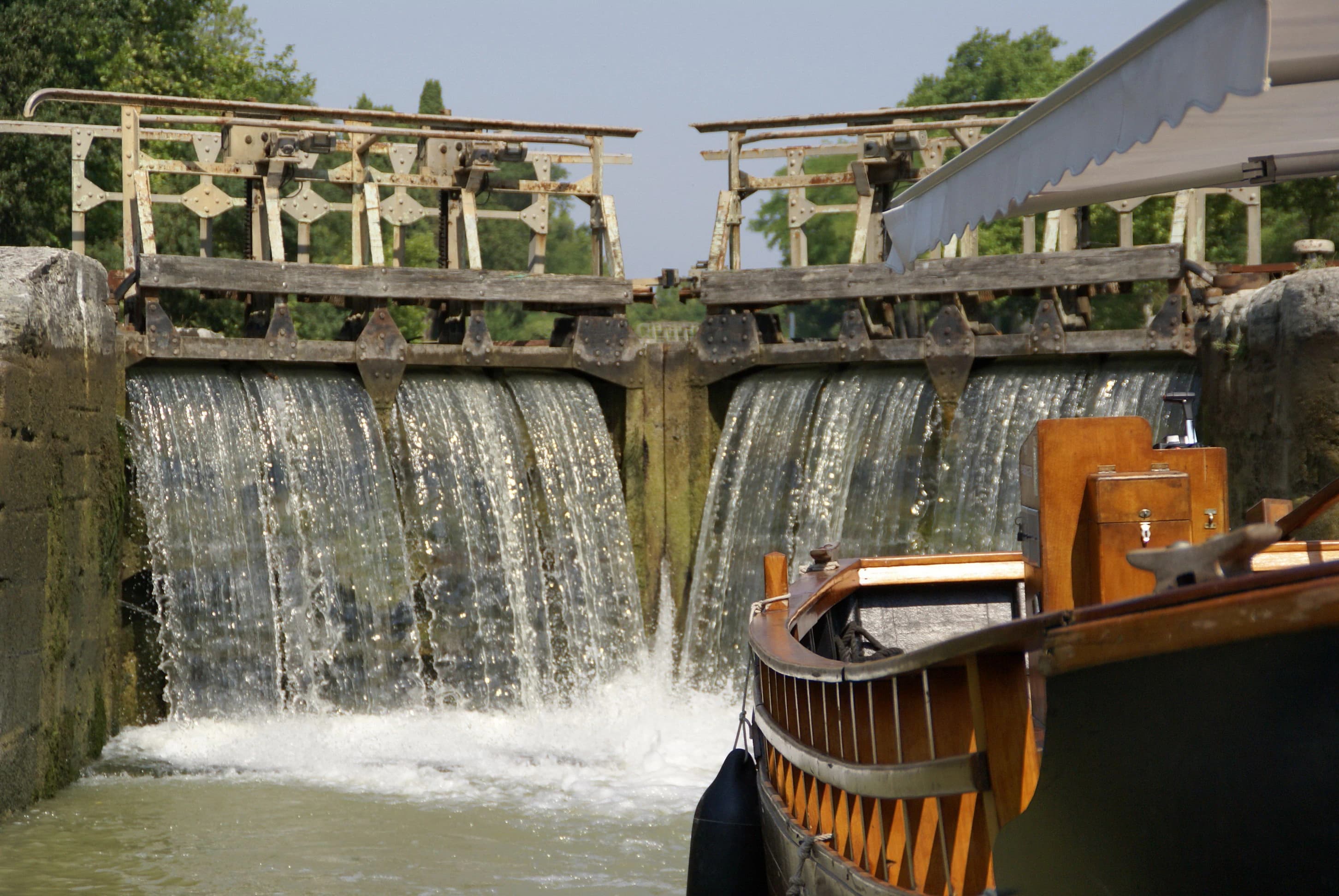 Boat passing through a canal lock with water flowing.