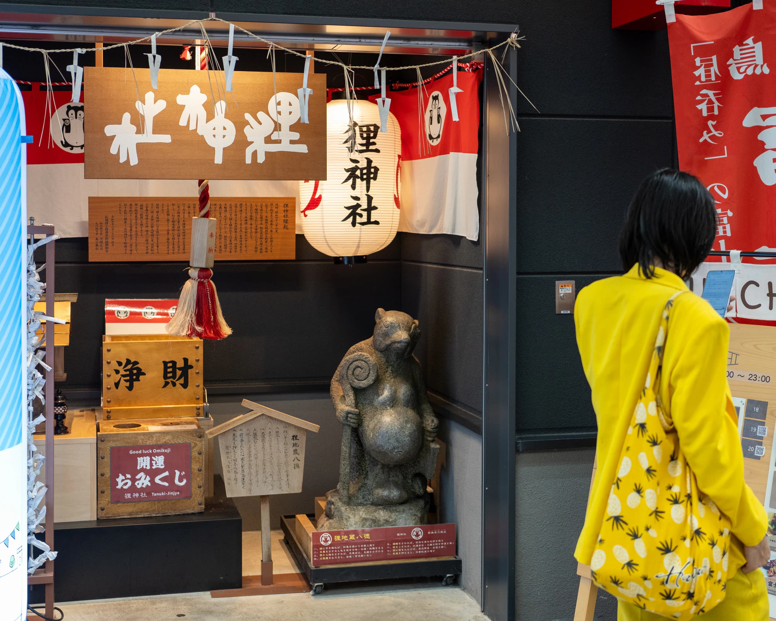 A woman in a yellow jacket looking at a display case