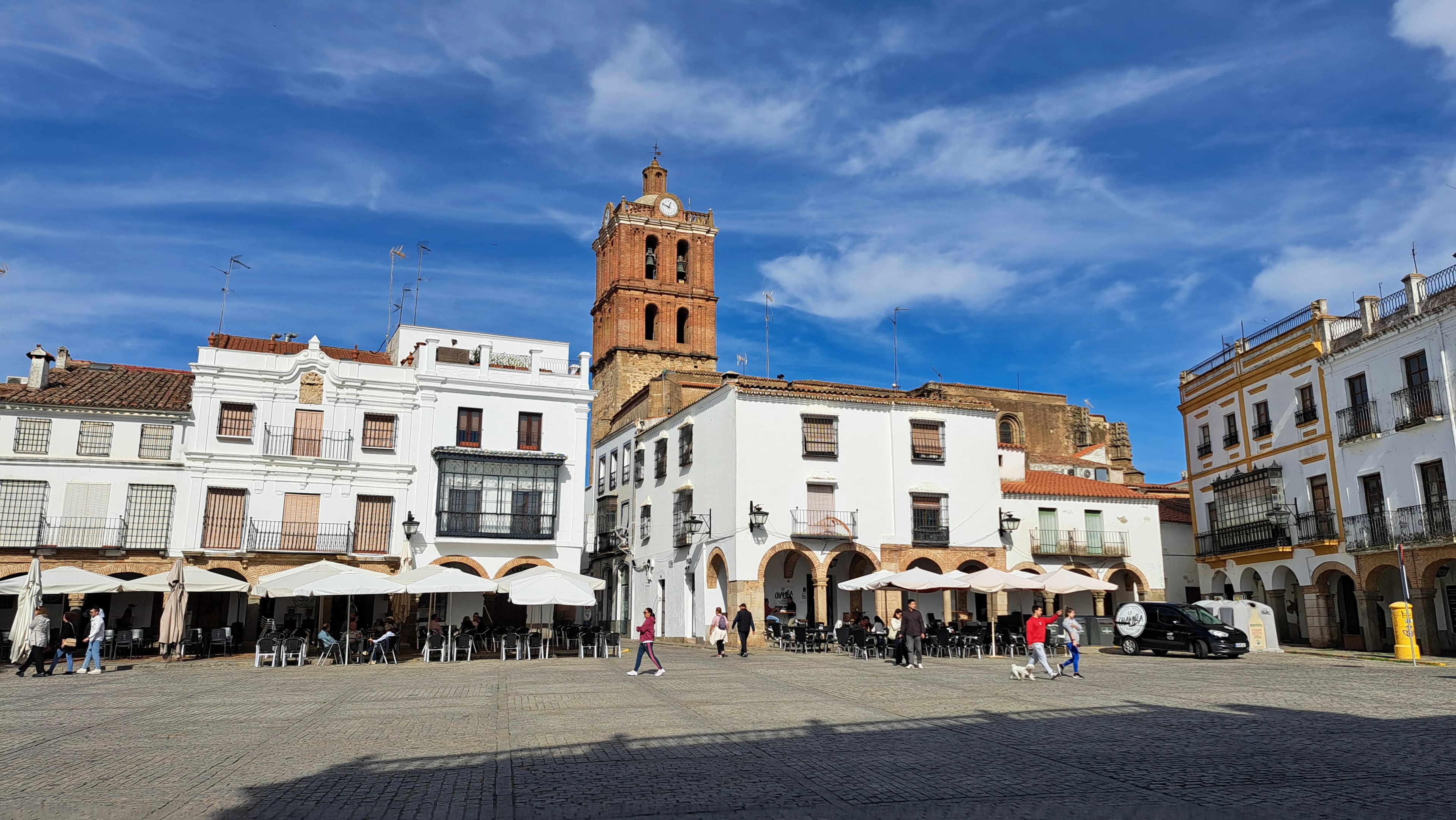 A city square with a clock tower in the background
