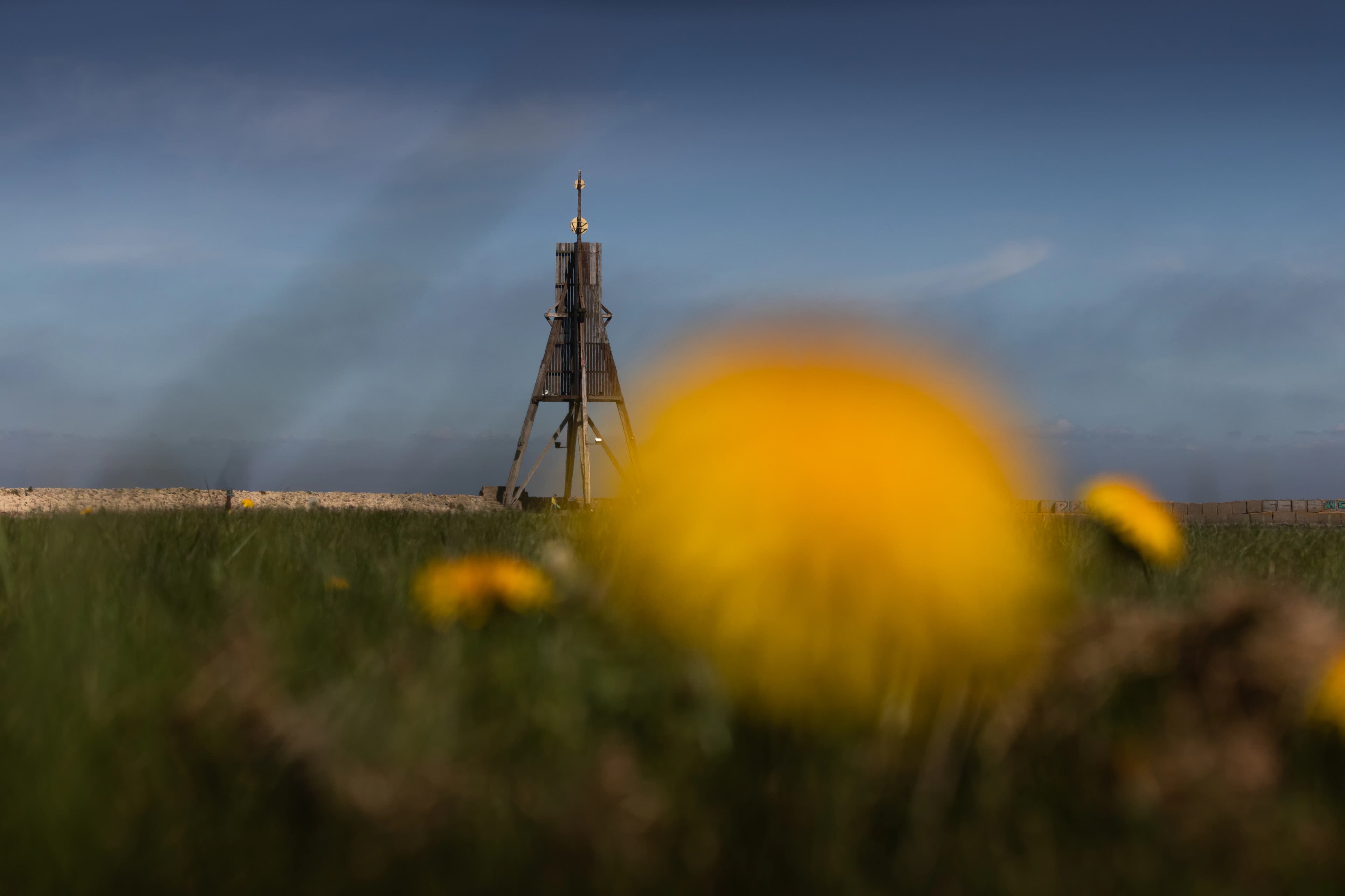 A lighthouse stands tall on a grassy field.