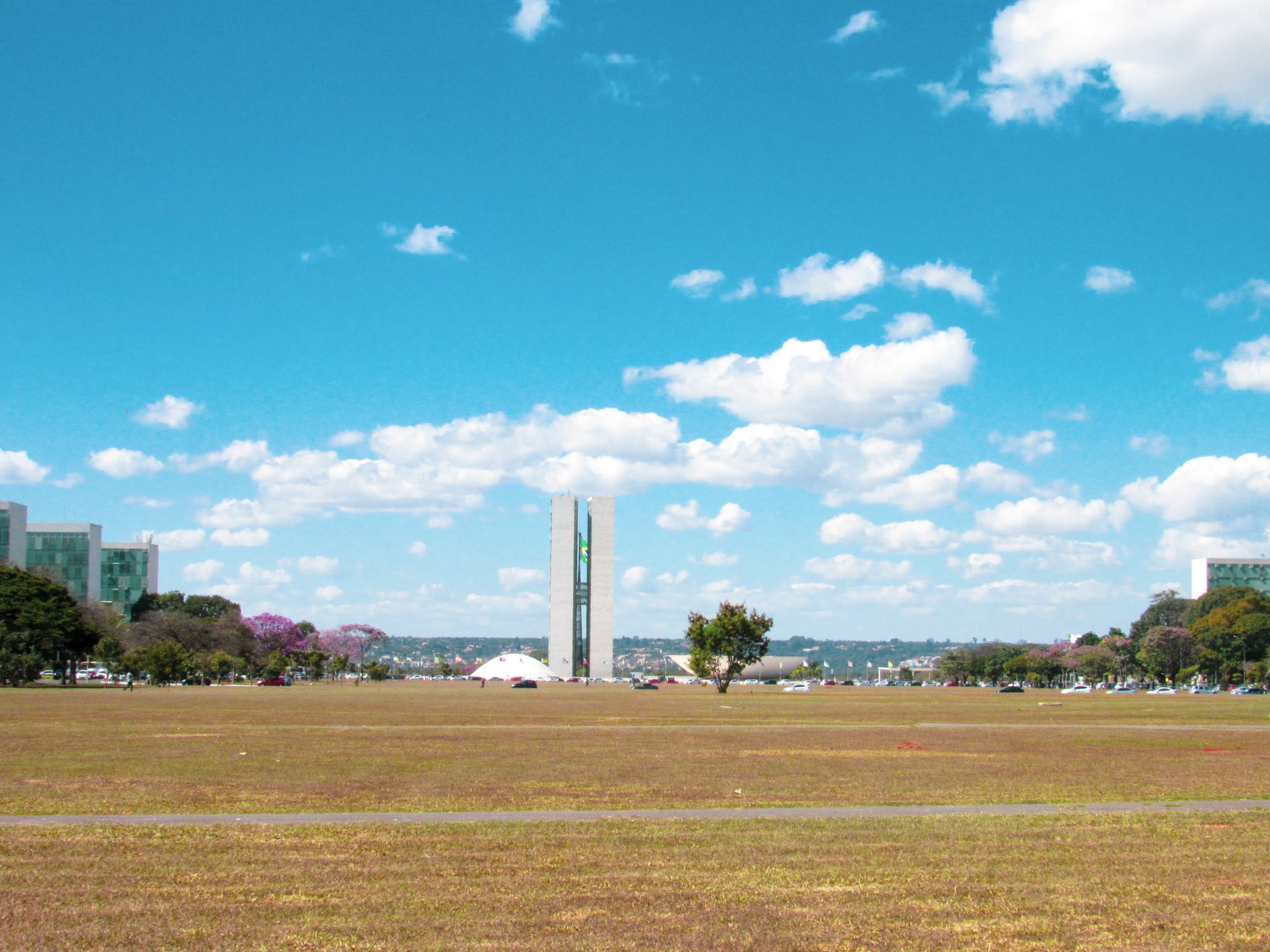 green grass field under blue sky and white clouds during daytime