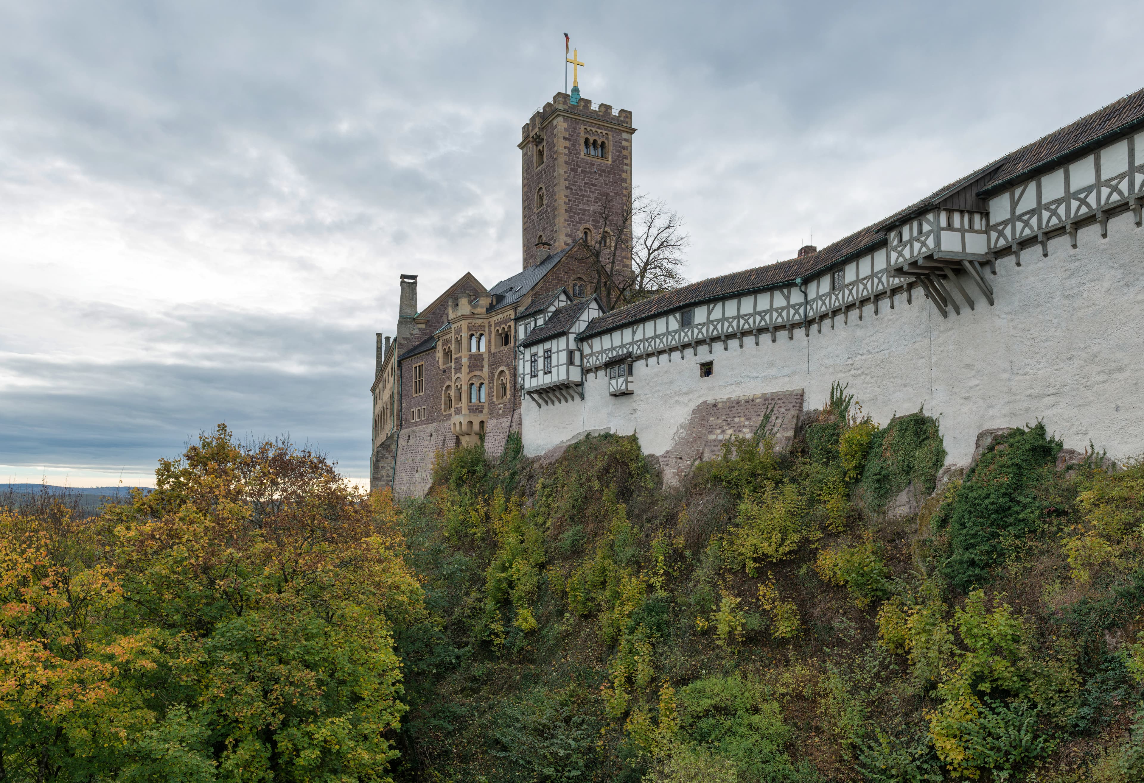 A large castle perched on a hill with trees.