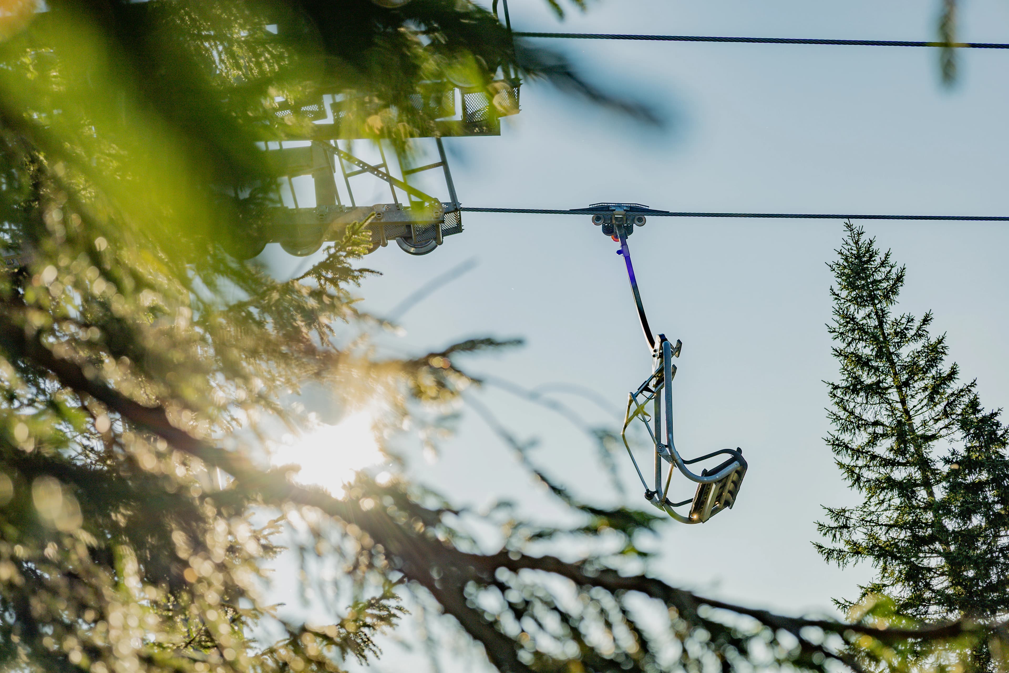Empty ski lift chair moving through trees