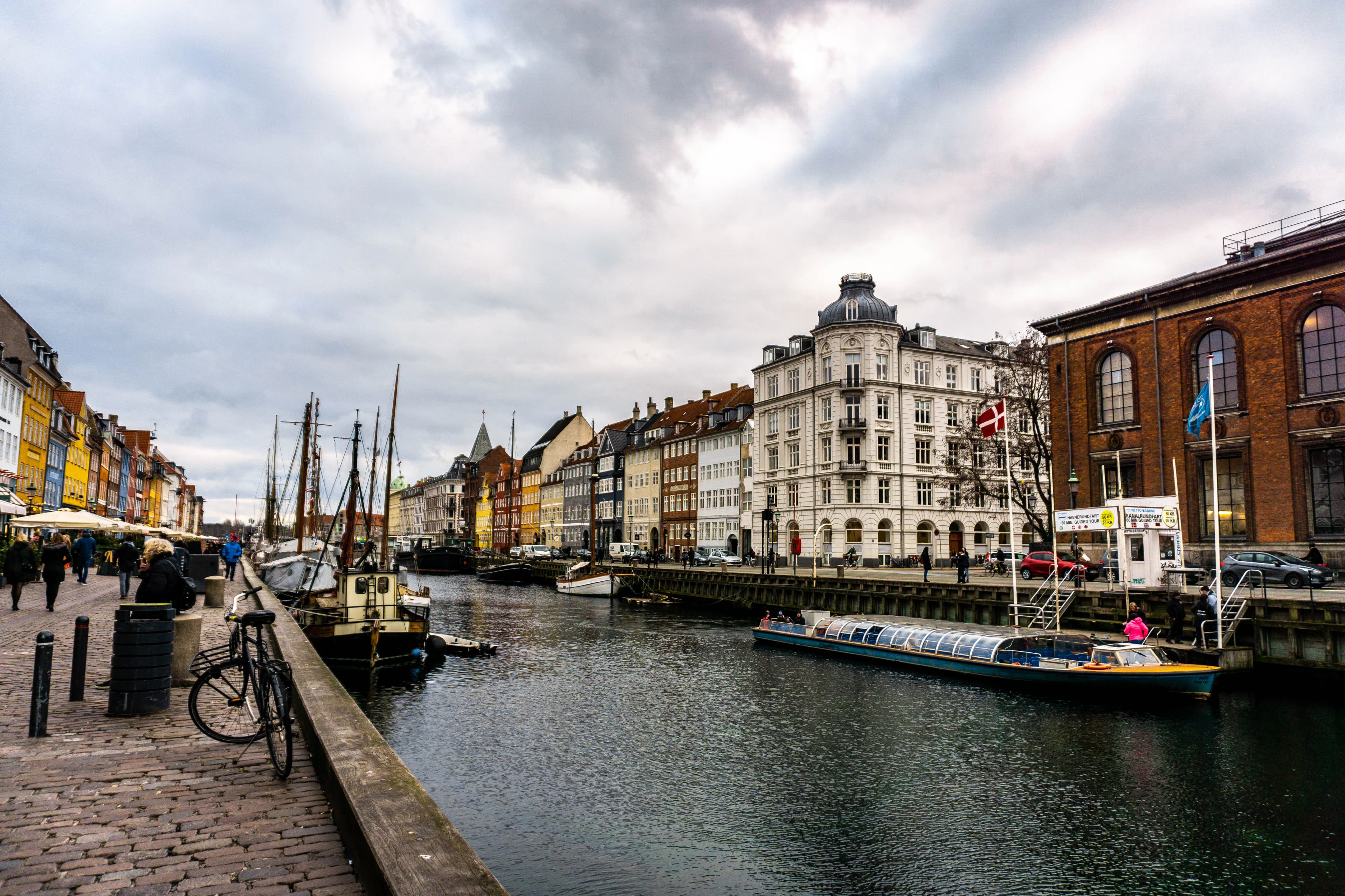 boats on body of water viewing multicolored buildings under white and gray sky during daytime