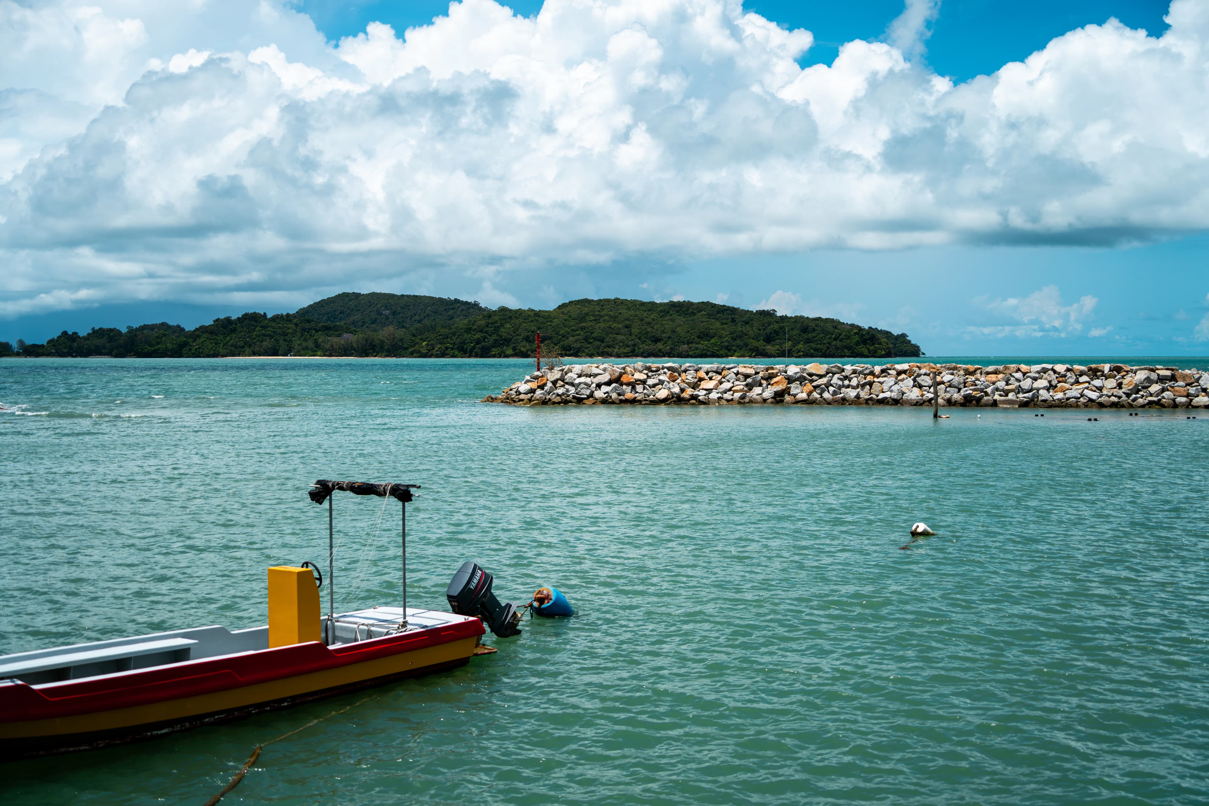 A small boat floating on top of a large body of water