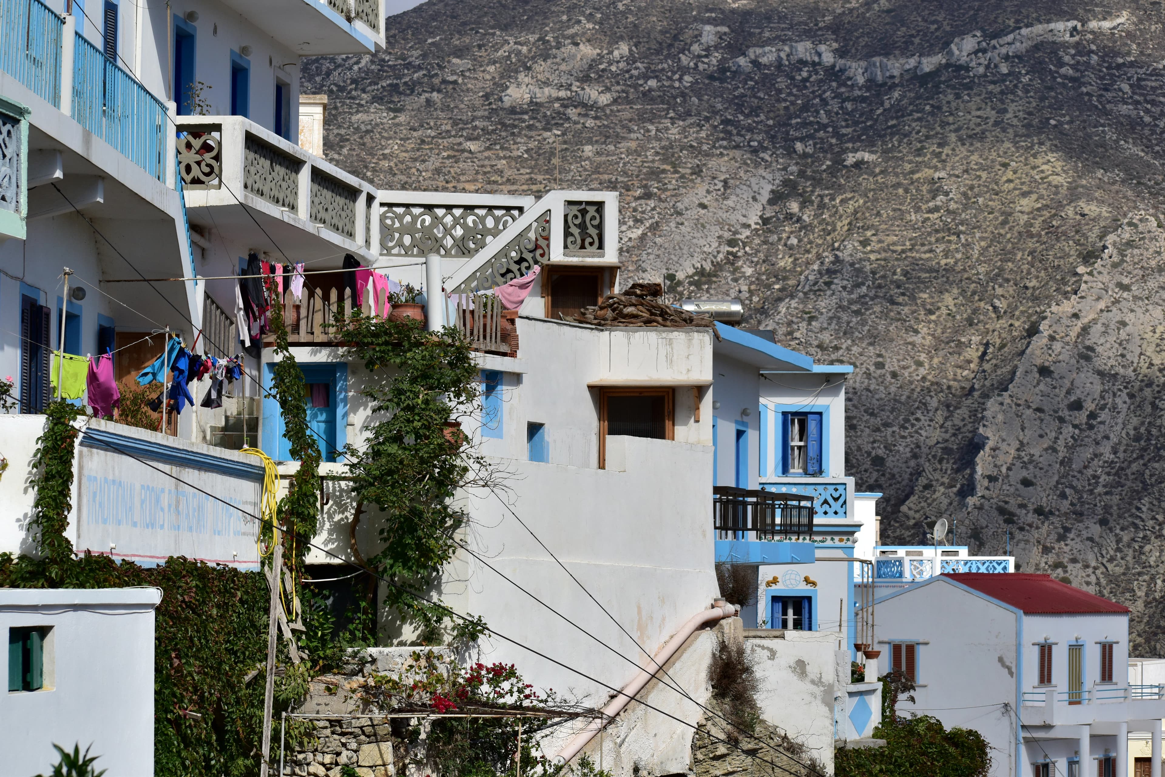 Whitewashed buildings on a hillside with a mountain.