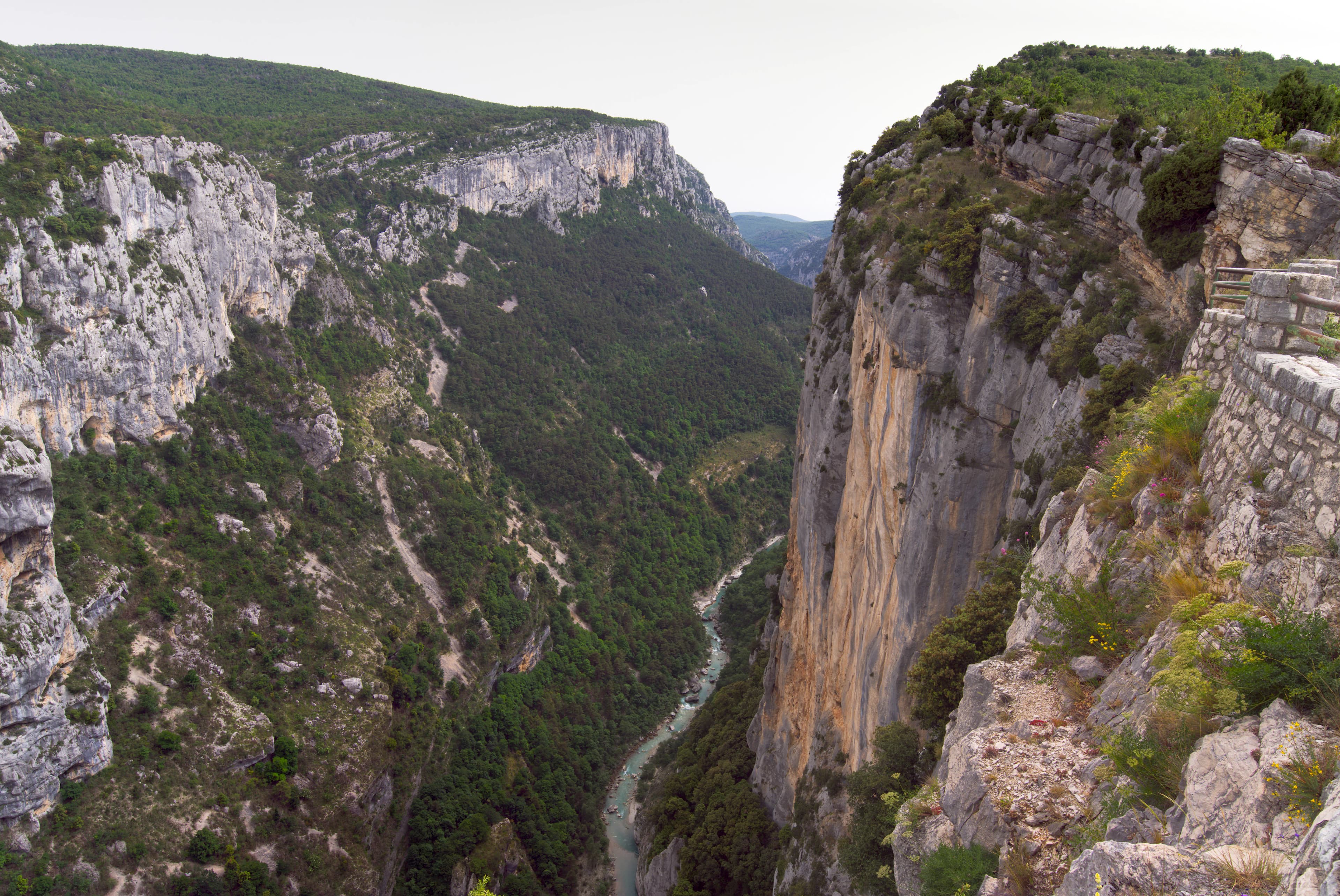 A man standing on a cliff overlooking a river