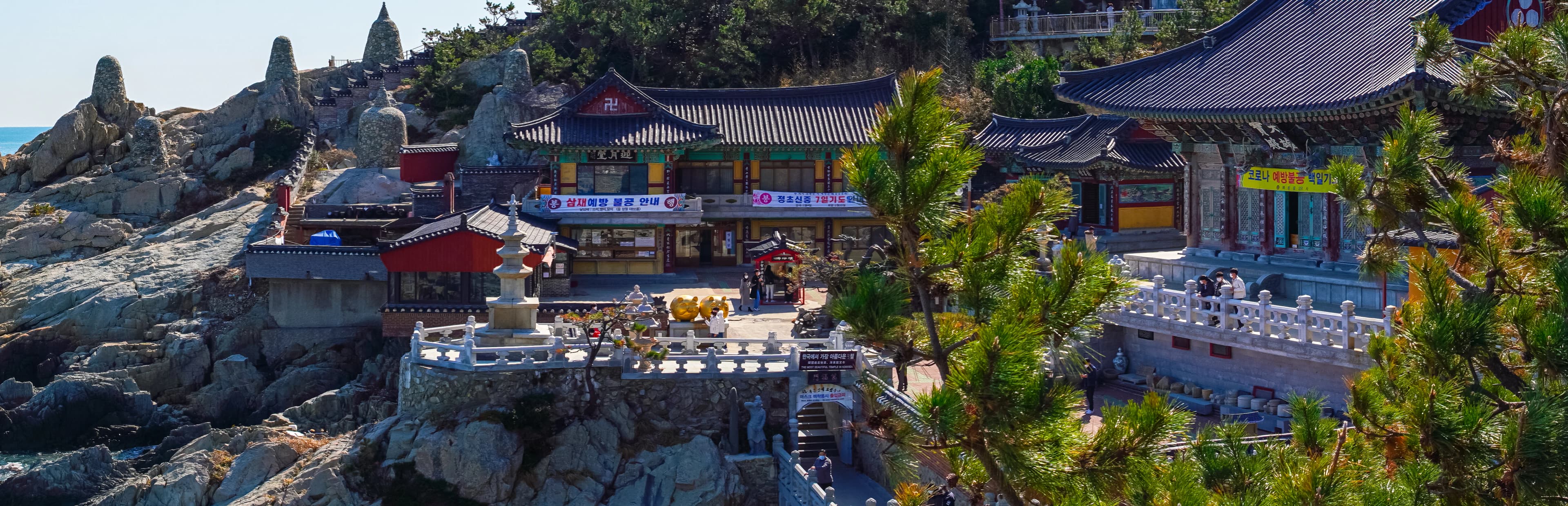 a group of buildings with trees and rocks in front of them