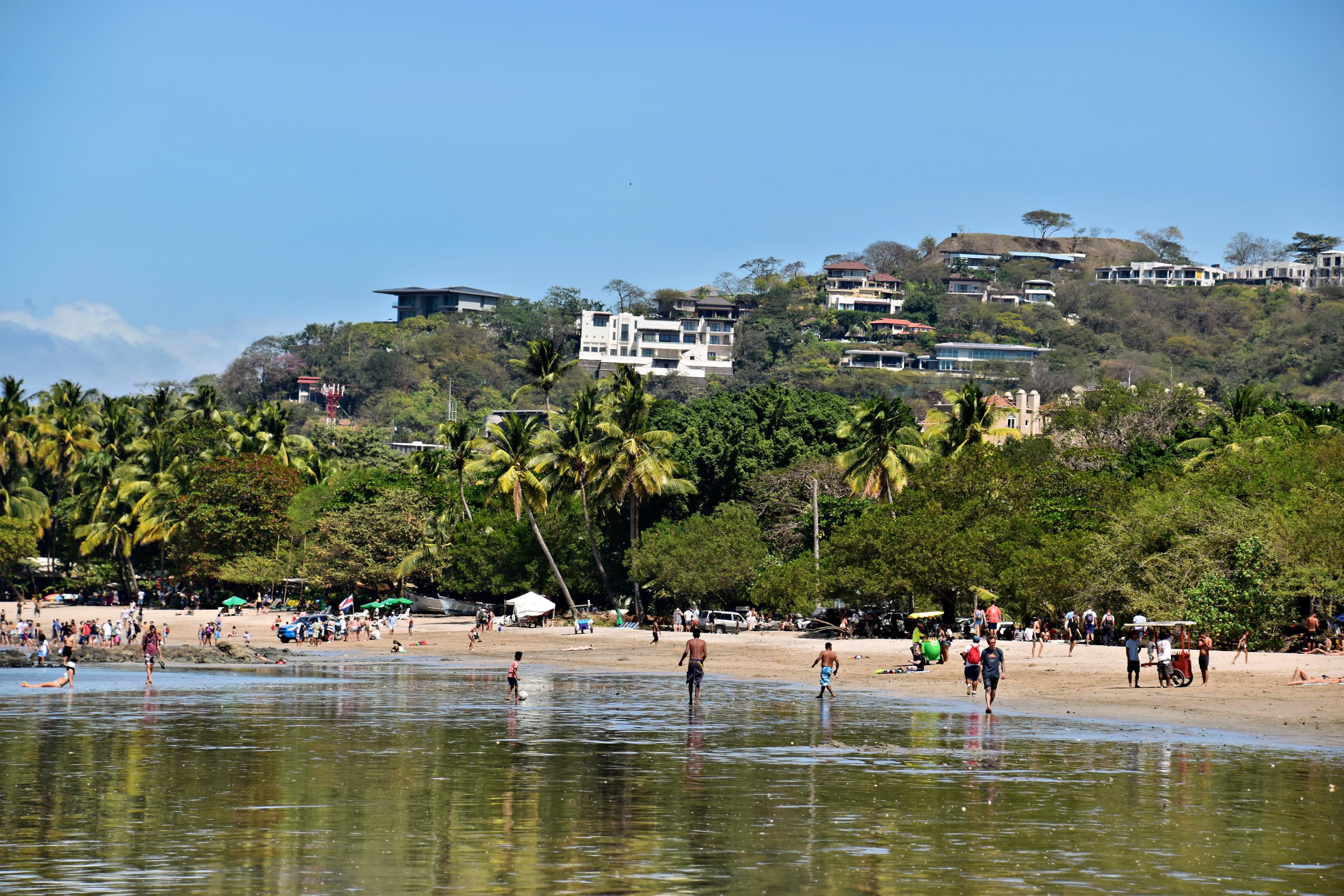a group of people standing on top of a sandy beach