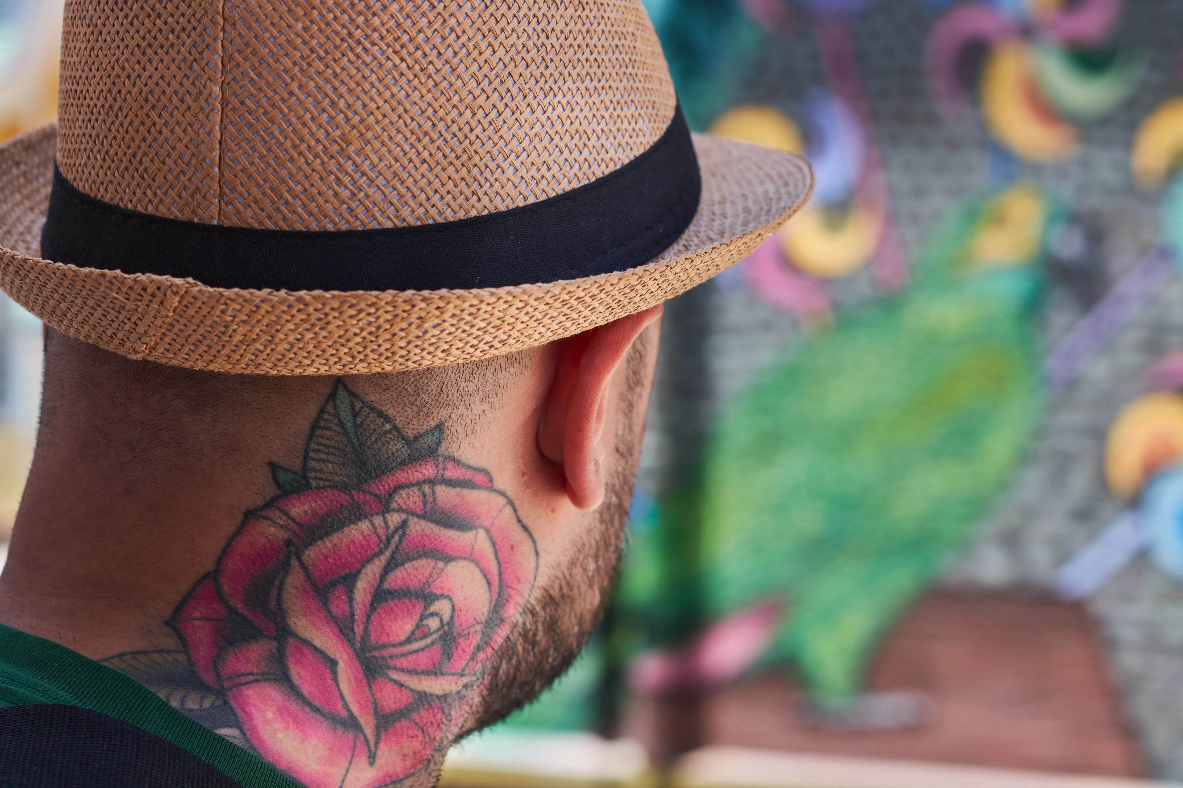 a man with a rose tattoo on his neck