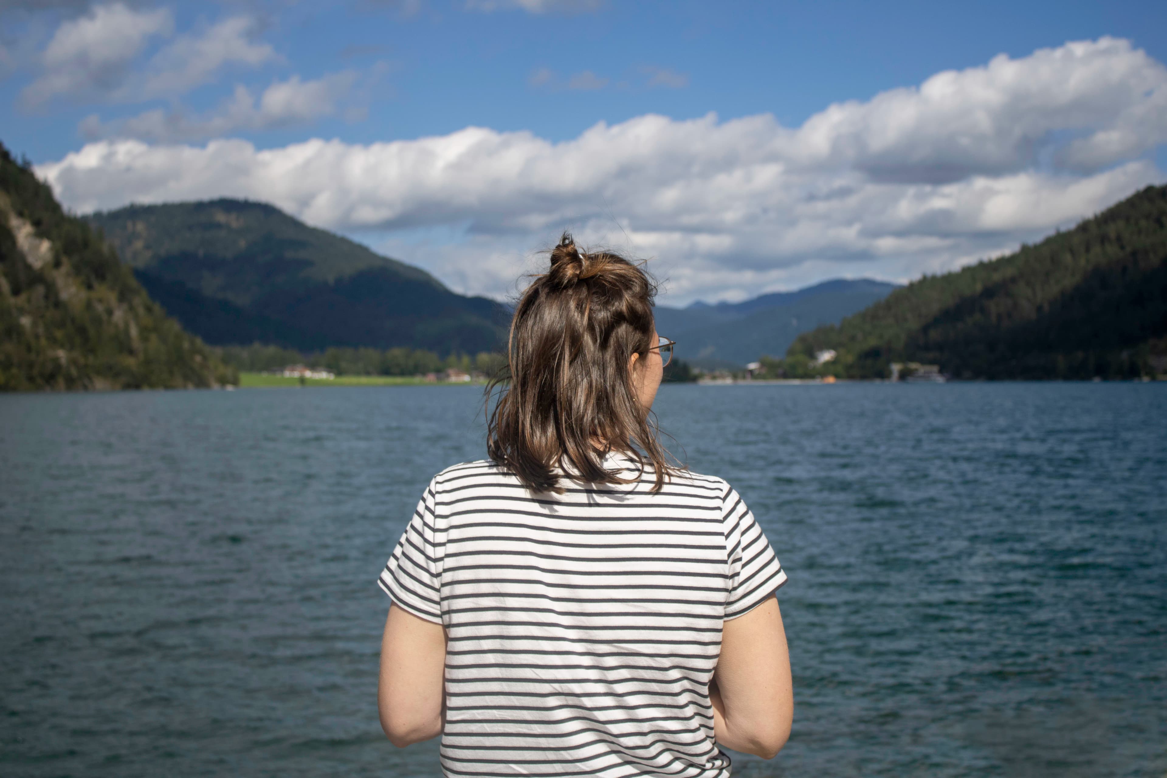 a woman standing in front of a body of water