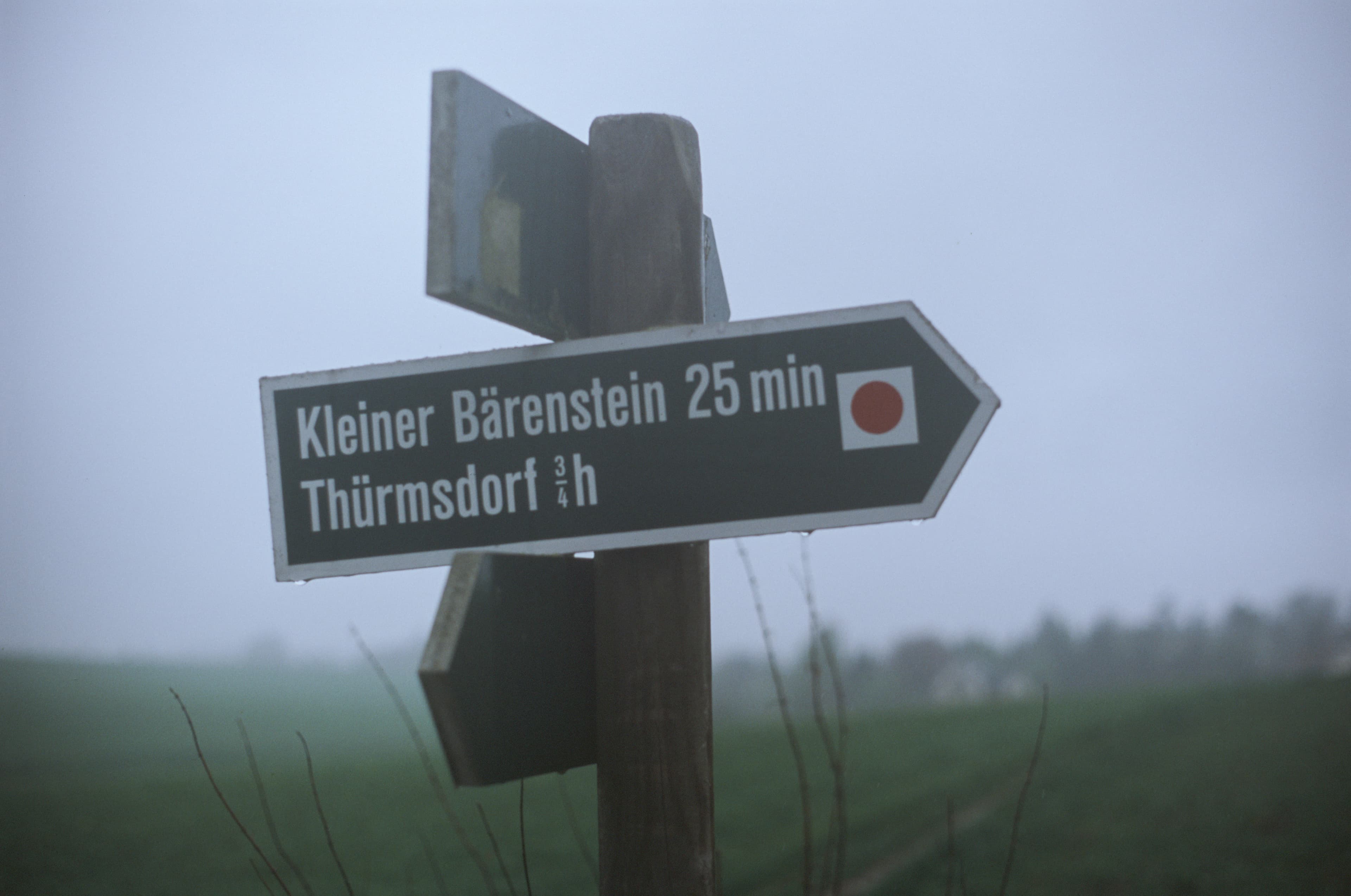 Signpost indicates direction and distance to nearby locations.