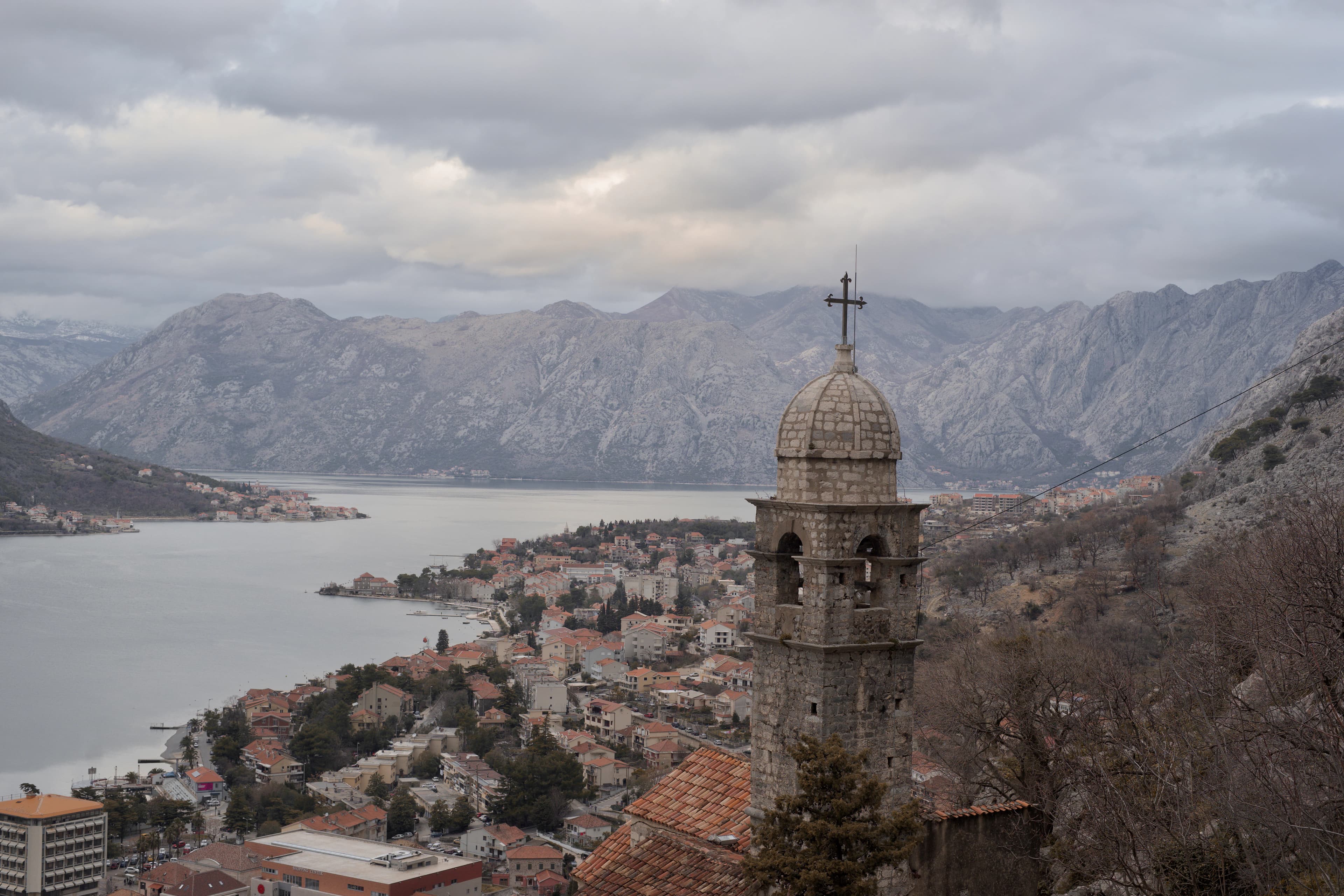 a view of a city with a lake and mountains in the background