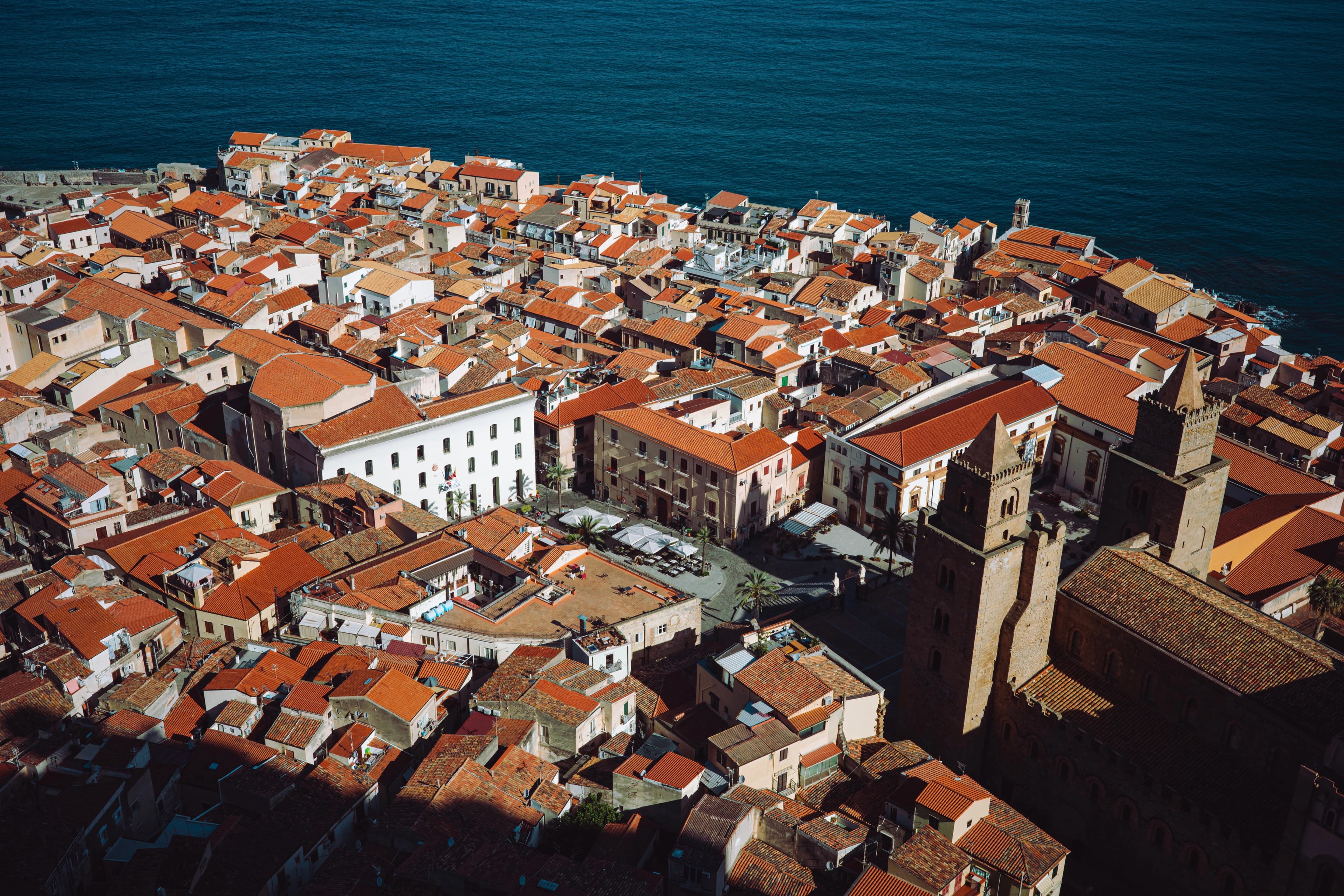 Aerial view of a coastal town with red roofs.