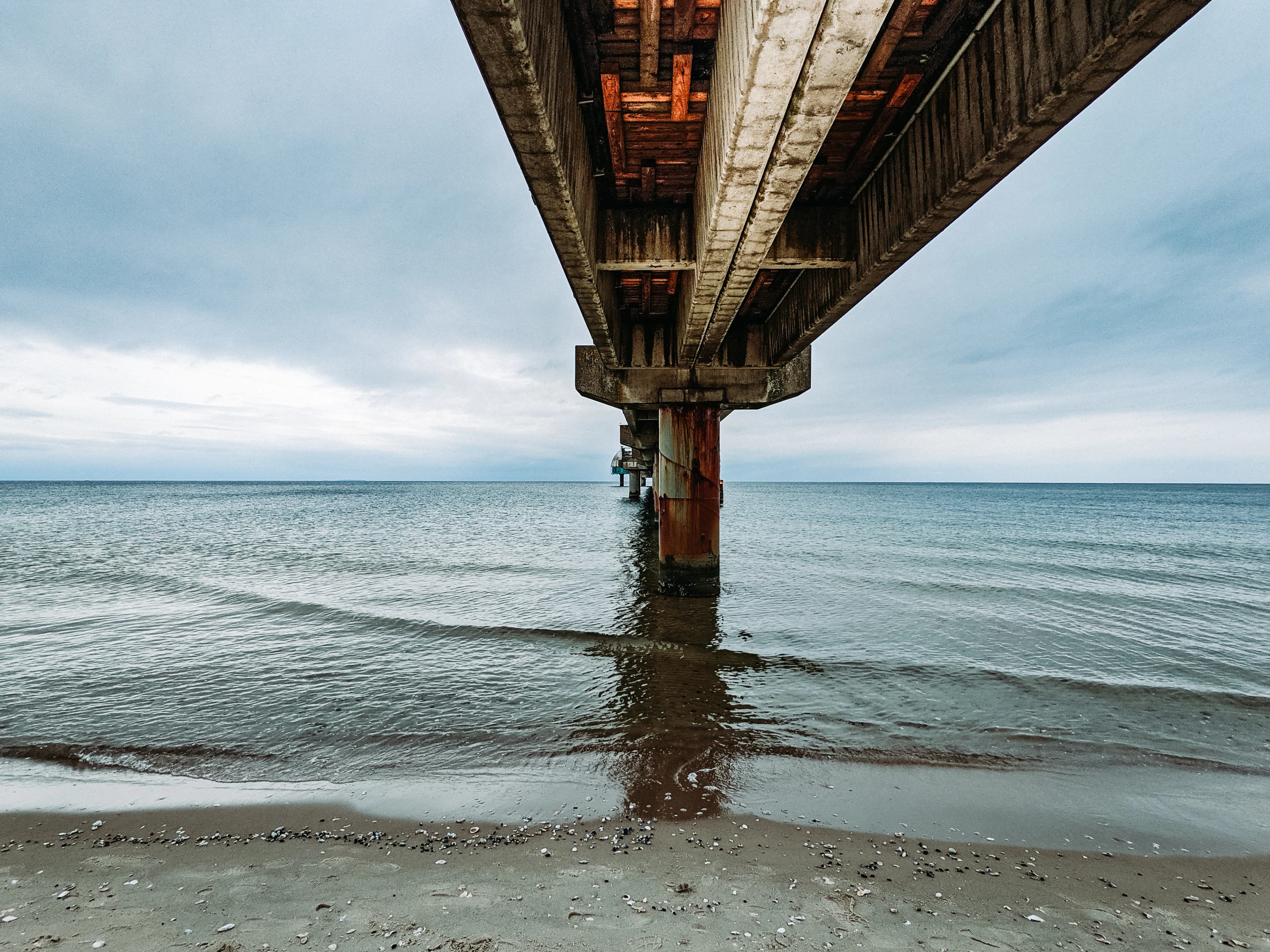 brown wooden bridge over the sea during daytime