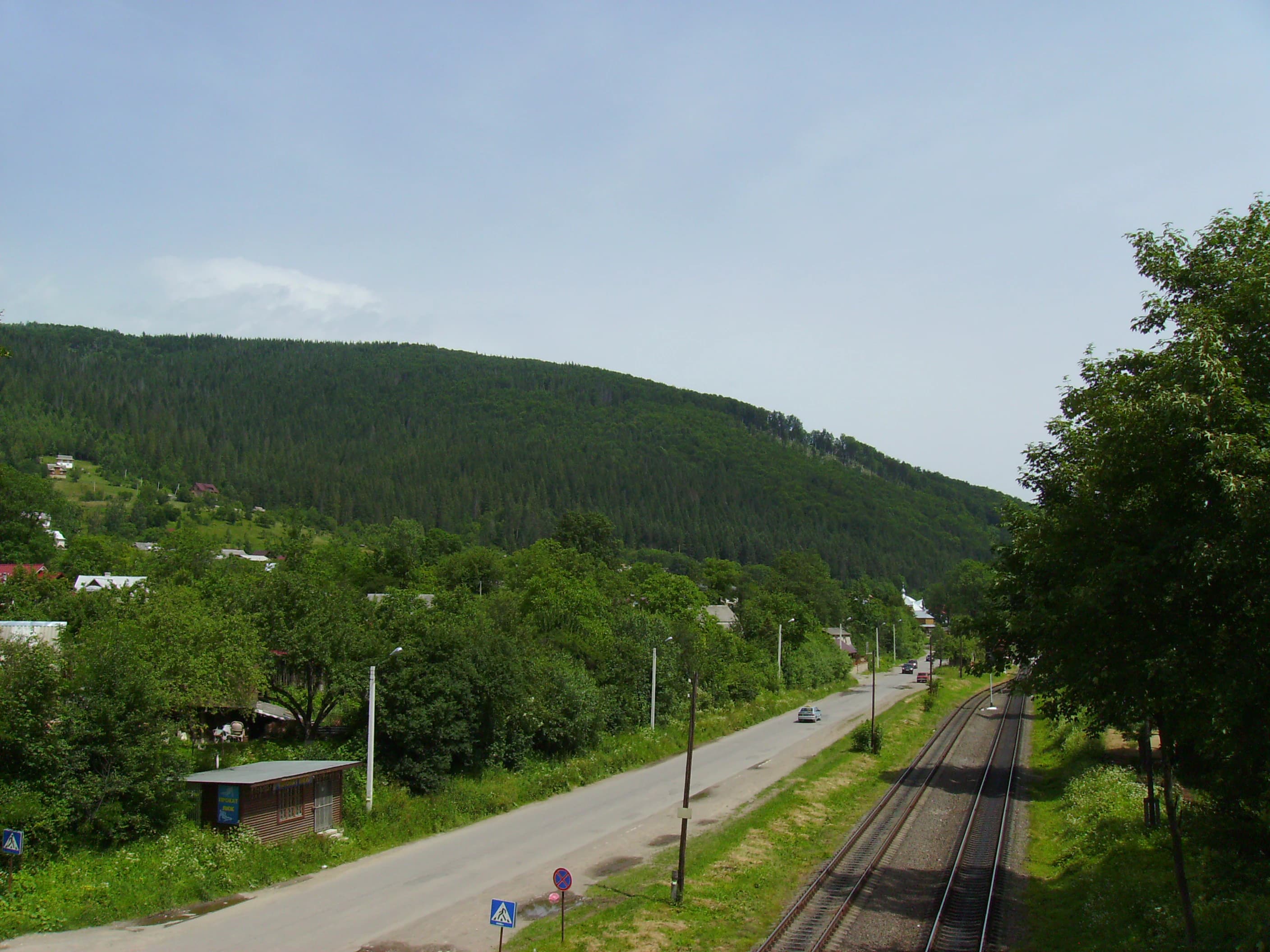 a view of a mountain with a train on the tracks