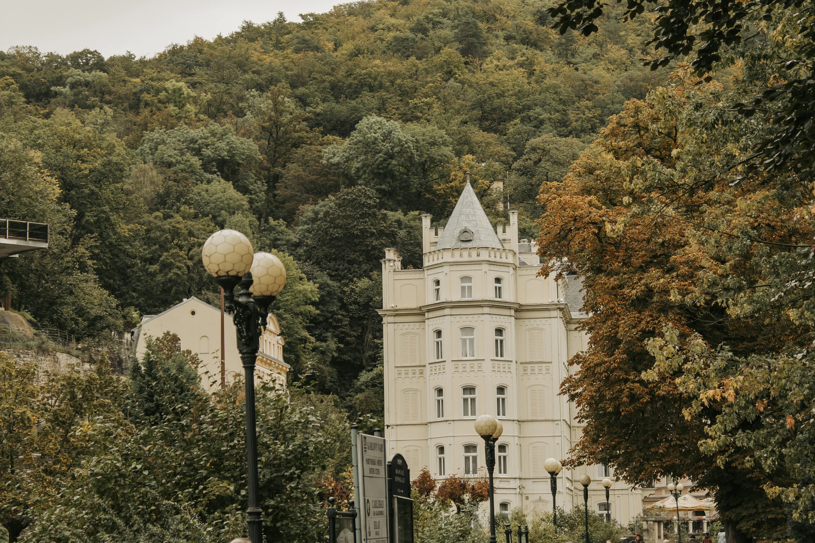 A large white building sitting on top of a lush green hillside