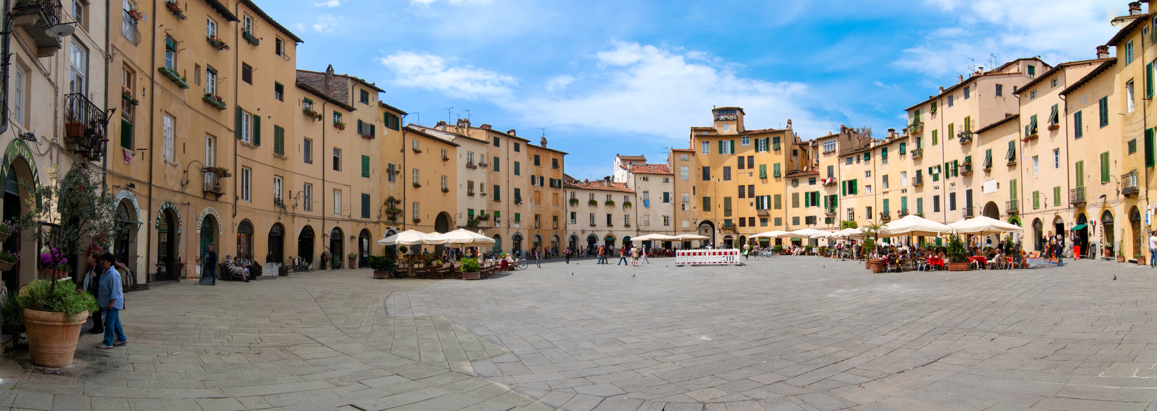 A wide open courtyard with tables and umbrellas