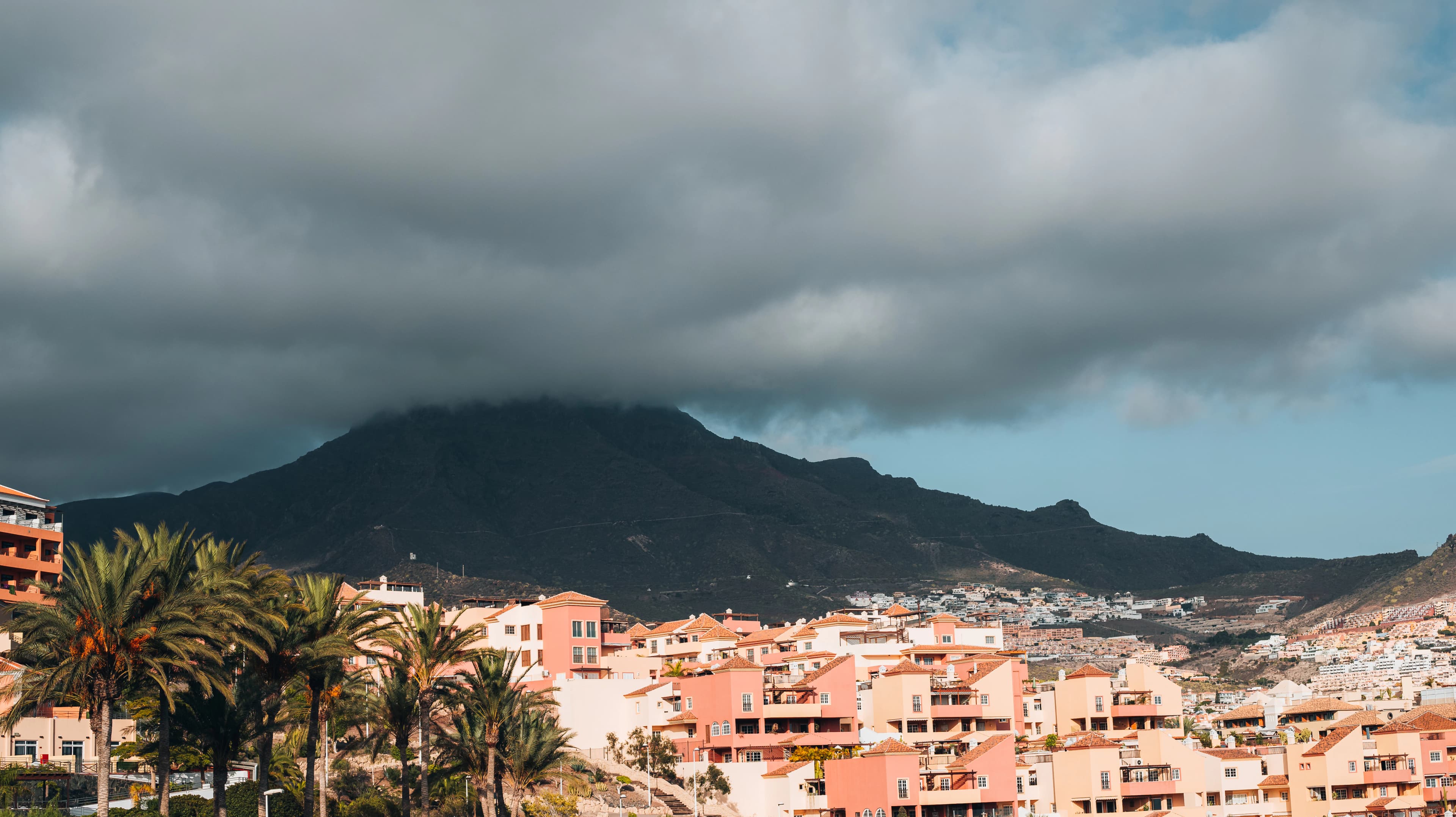 a city with trees and mountains in the background