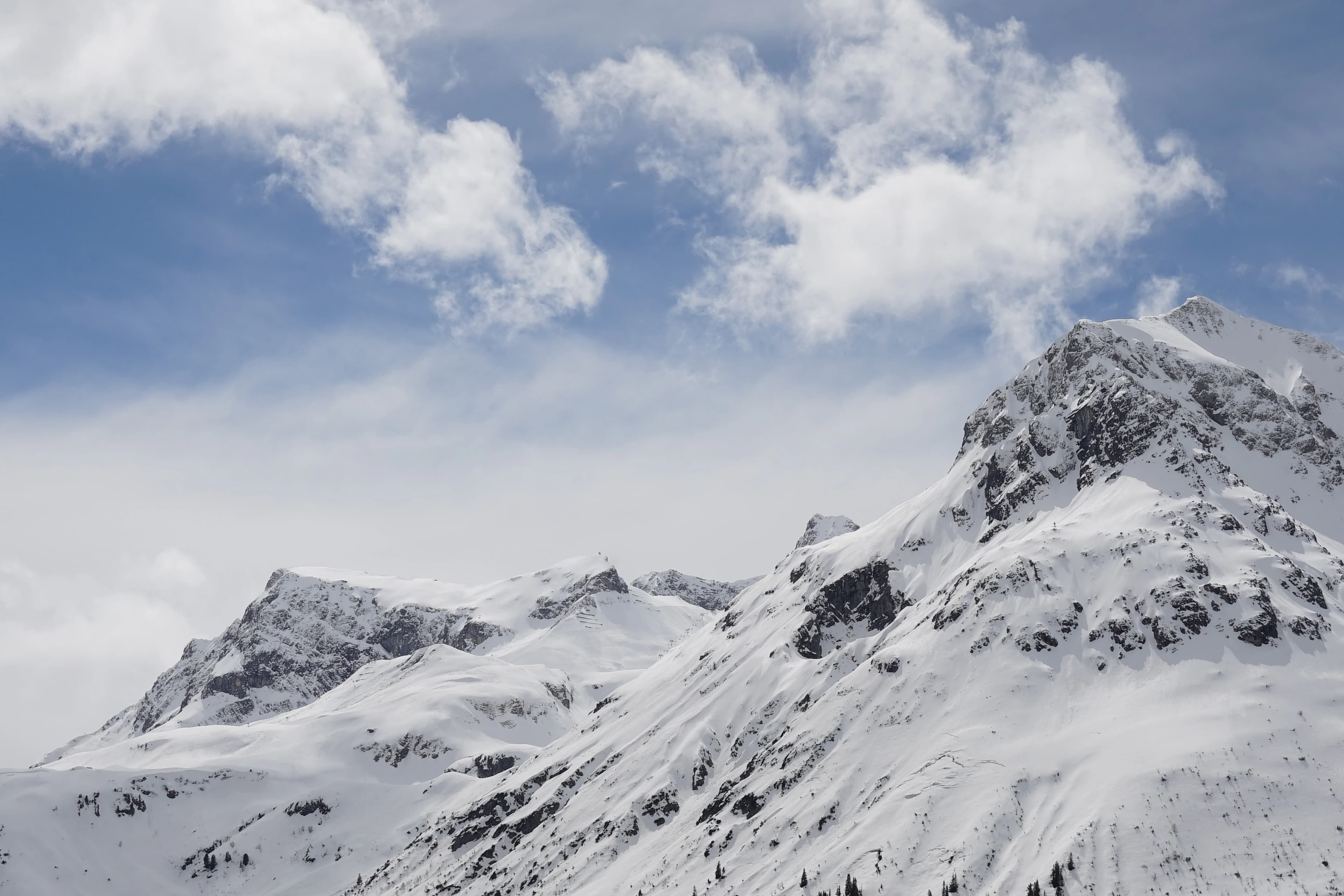 A mountain covered in snow under a cloudy sky