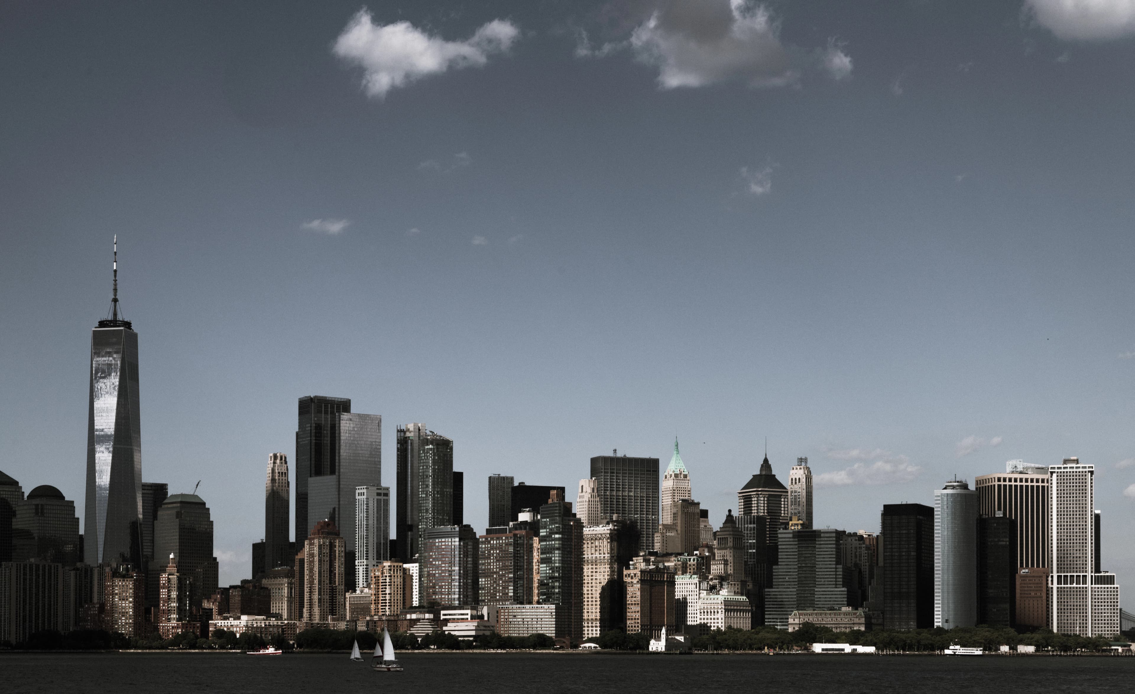 a city skyline with a sailboat in the foreground