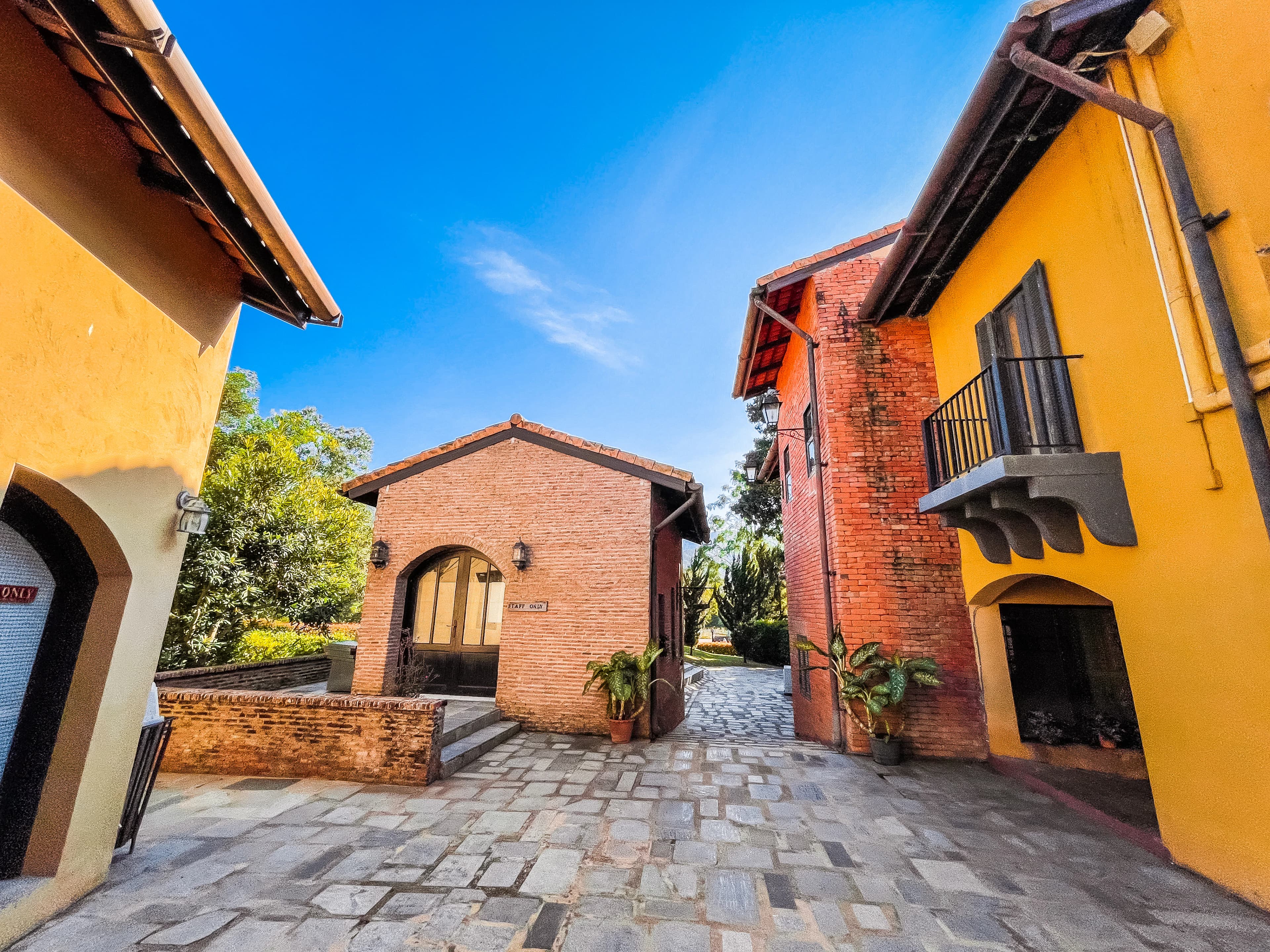 an alley way with a brick building and a blue sky