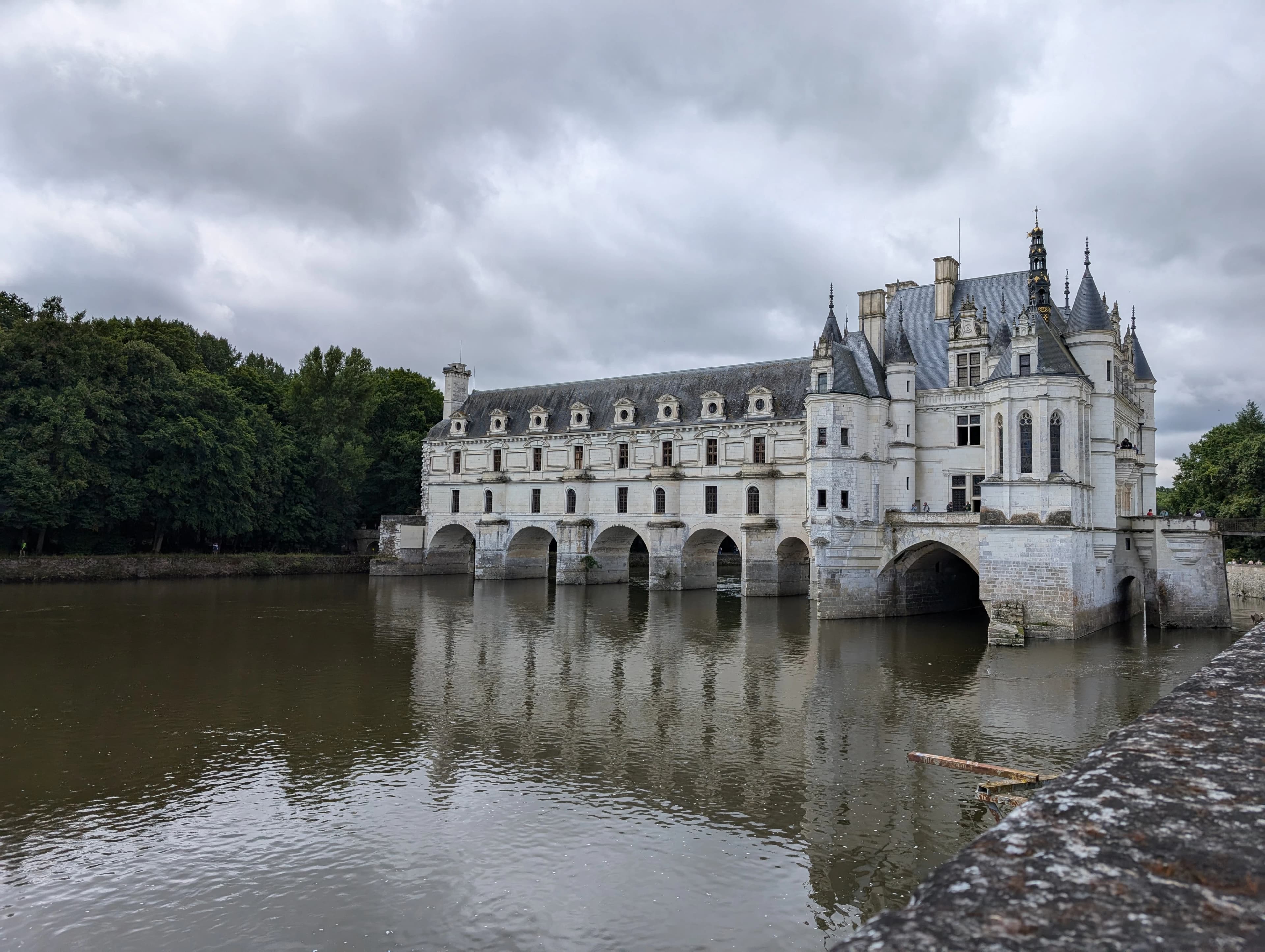 A castle sitting on top of a river next to a bridge