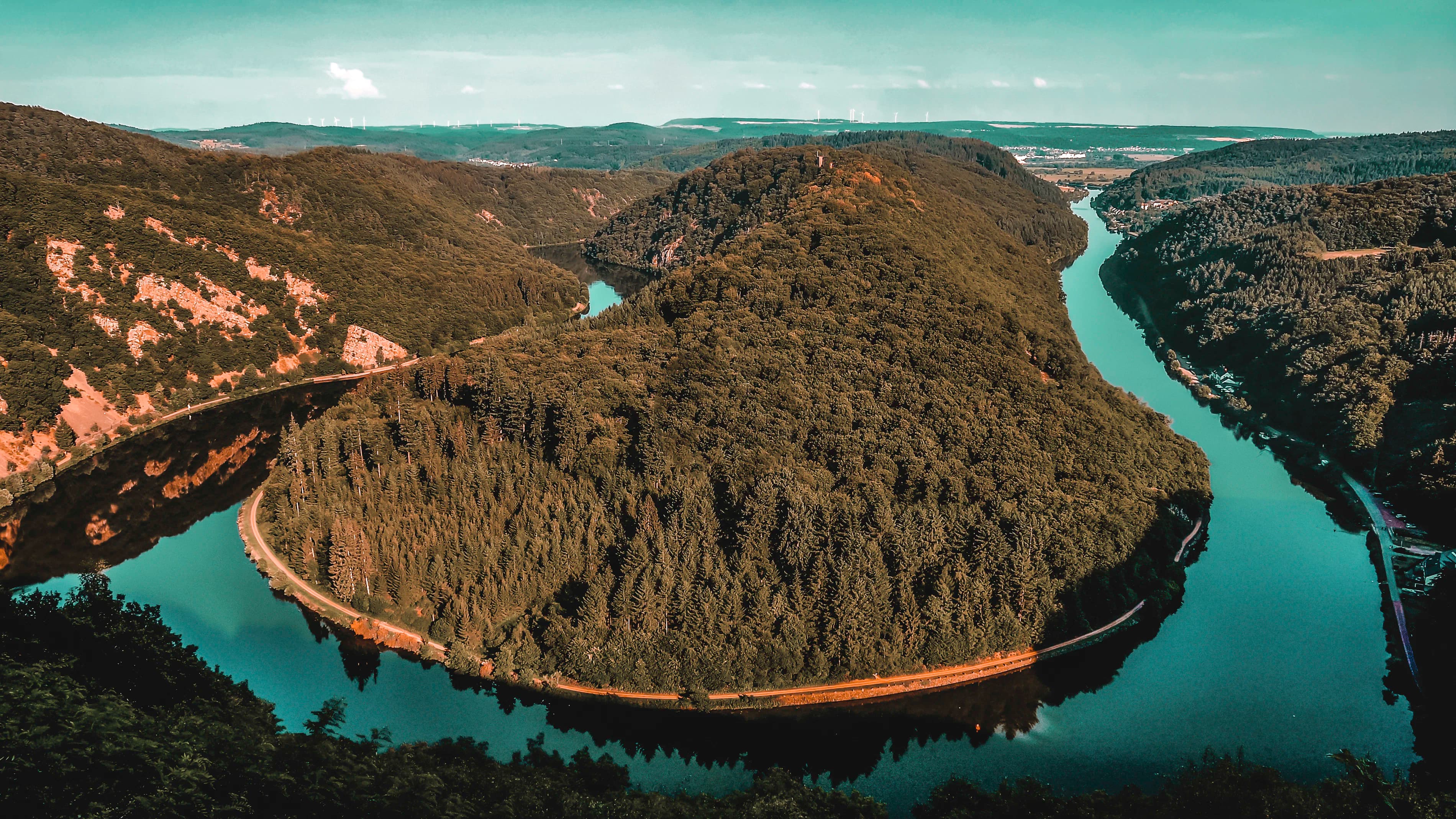 brown and green mountain beside blue body of water during daytime